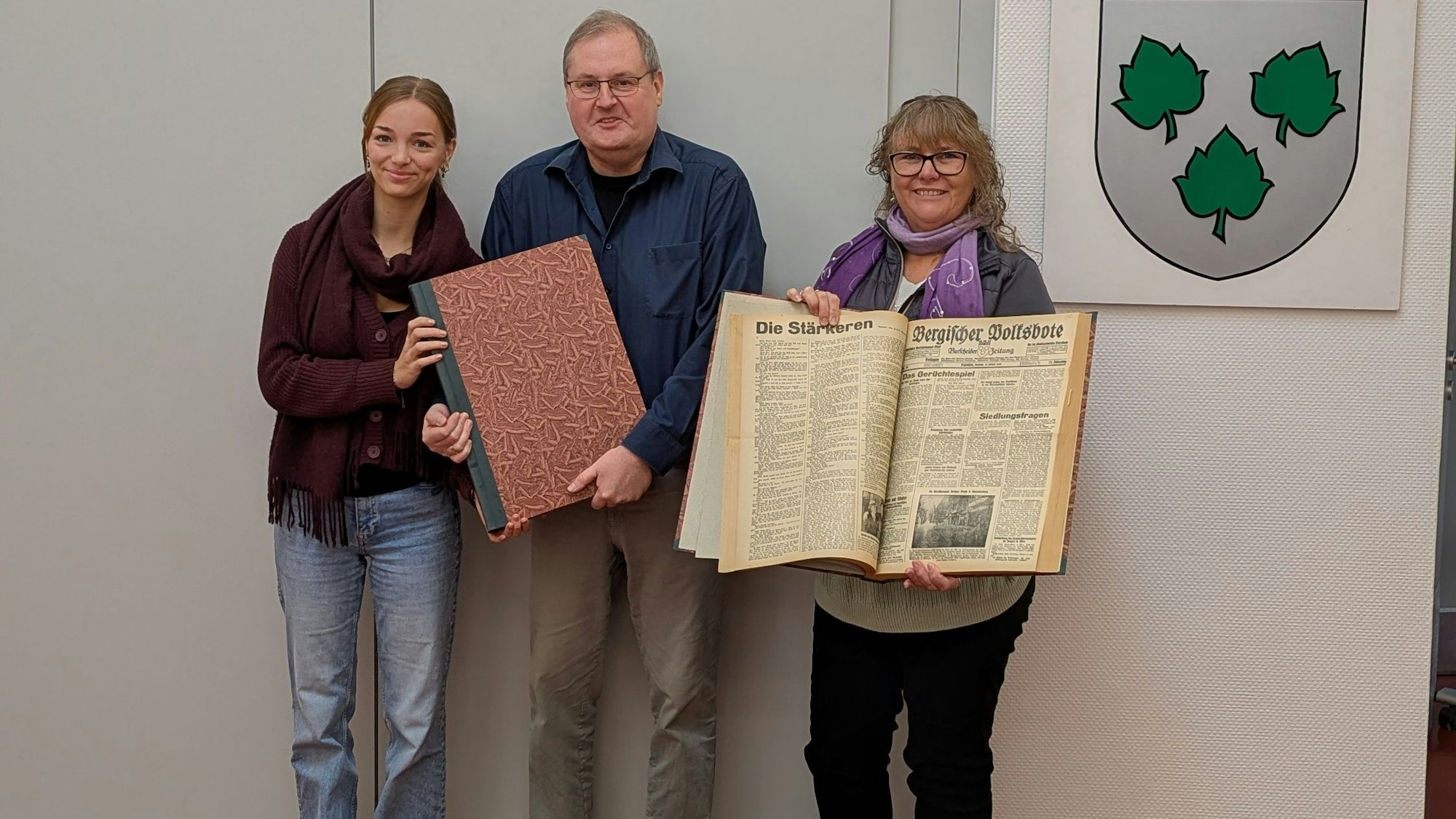 Die Zeitungsbände umfassen Ausgaben der lokalen Tageszeitung, die inzwischen im Remscheider Generalanzeiger aufgegangen ist, von Oktober bis Dezember 1932 und von Januar bis März 1933. Von links: v.l.: Julia Göde (Mitarbeiterin des Stadtarchivs im Bundesfreiwilligendienst), Norbert Bangert (Stadtarchivar), Regina Schmitter (Schenkungsgeberin aus Ontario, Kanada).