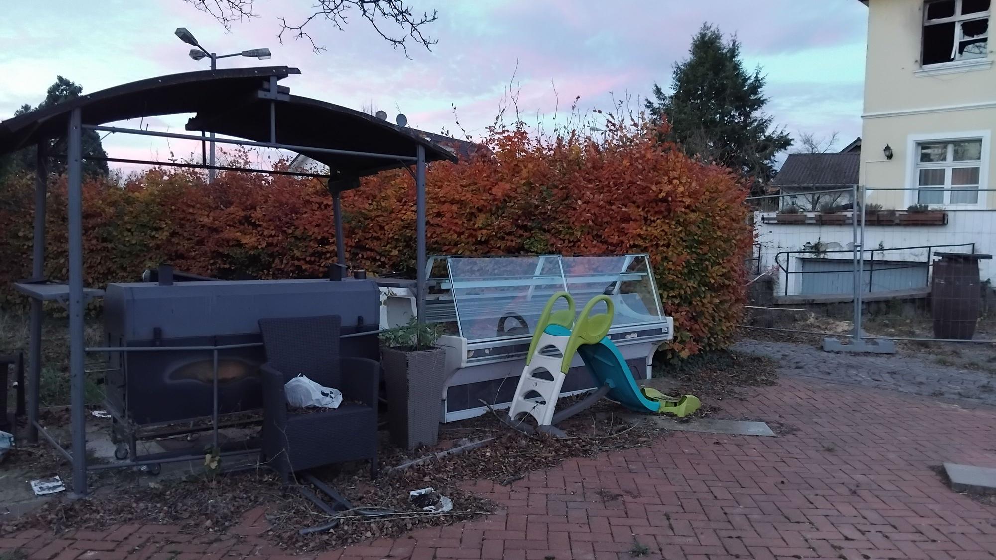 Auf der Terrasse steht noch eine ausgediente Kühltheke, ein Kinderfahrrad liegt neben einer Plastikrutsche.