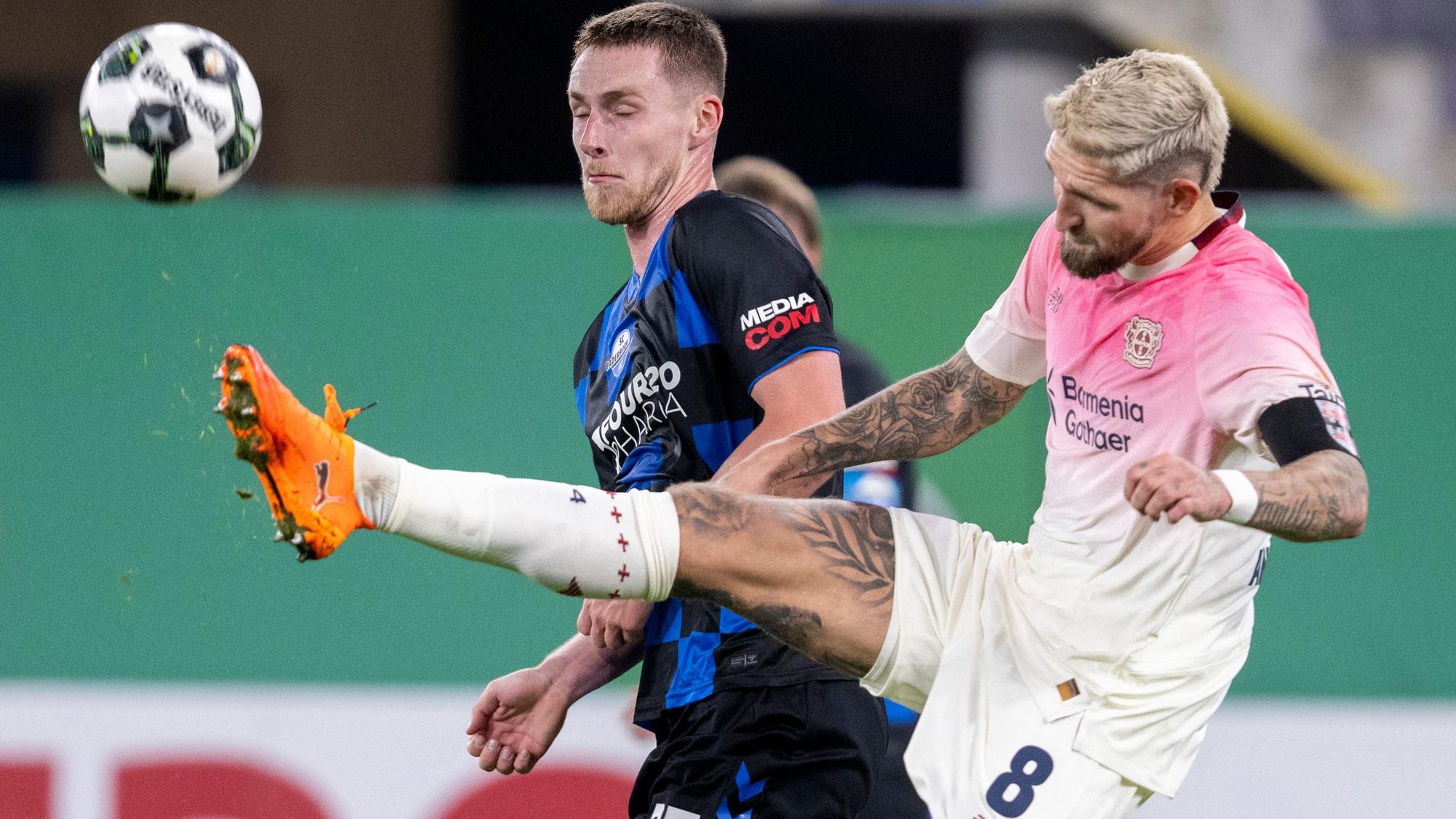 ARCHIV - 29.10.2025, Nordrhein-Westfalen, Paderborn: Fußball: DFB-Pokal, SC Paderborn 07 - Bayer Leverkusen, 2. Runde, Home Deluxe Arena: Tjark Scheller (SC Paderborn 07, l) und Robert Andrich (Bayer Leverkusen) kämpfen um den Ball. (zu dpa: «Trotz Konkurrenz im Mittelfeld: Hjulmand lobt Andrich») Foto: David Inderlied/dpa +++ dpa-Bildfunk +++