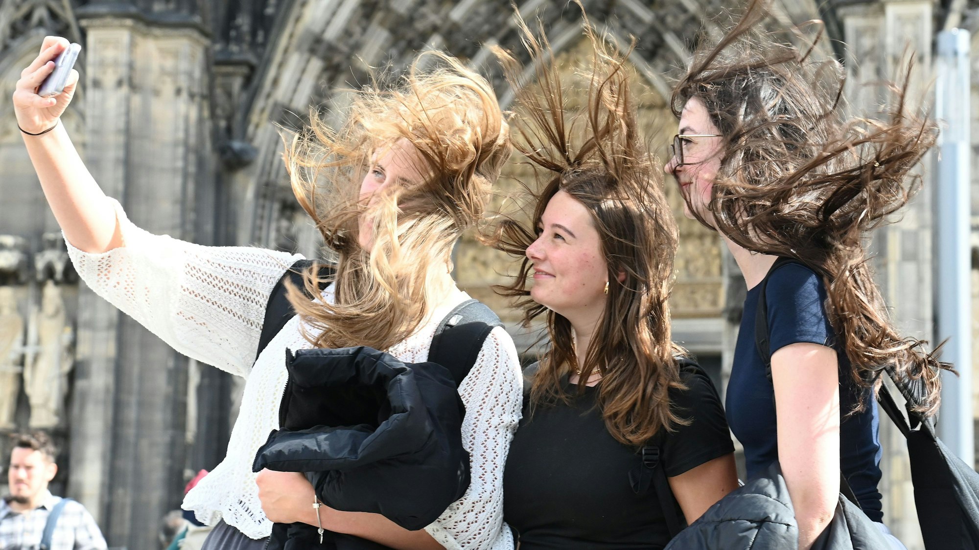 Drei Touristinnen versuchen bei starkem Wind ein Foto vor dem Dom zu machen. Alexander Schwaiger