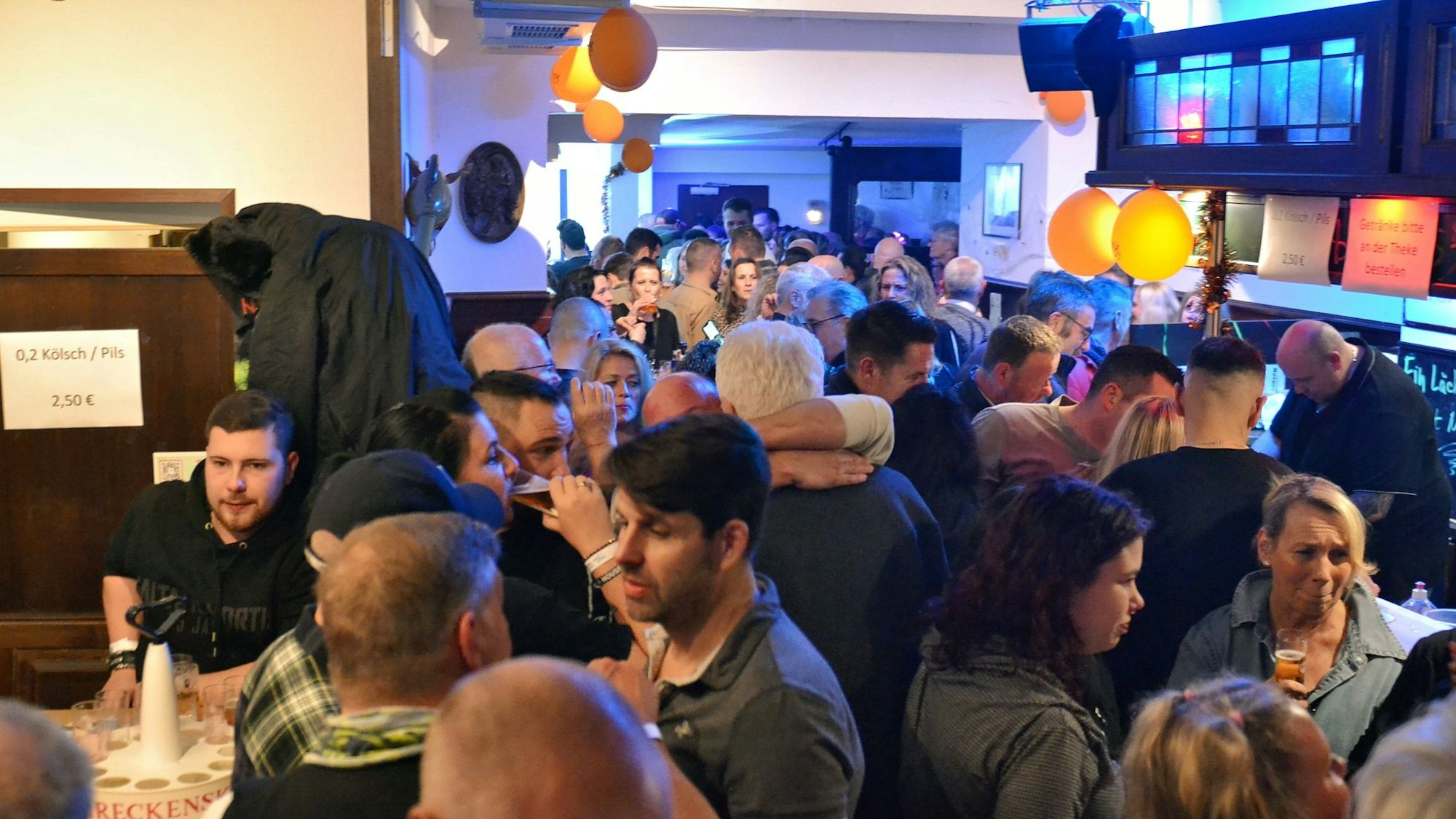 Die Gäste stehen dicht gedrängt in der Gaststätte.