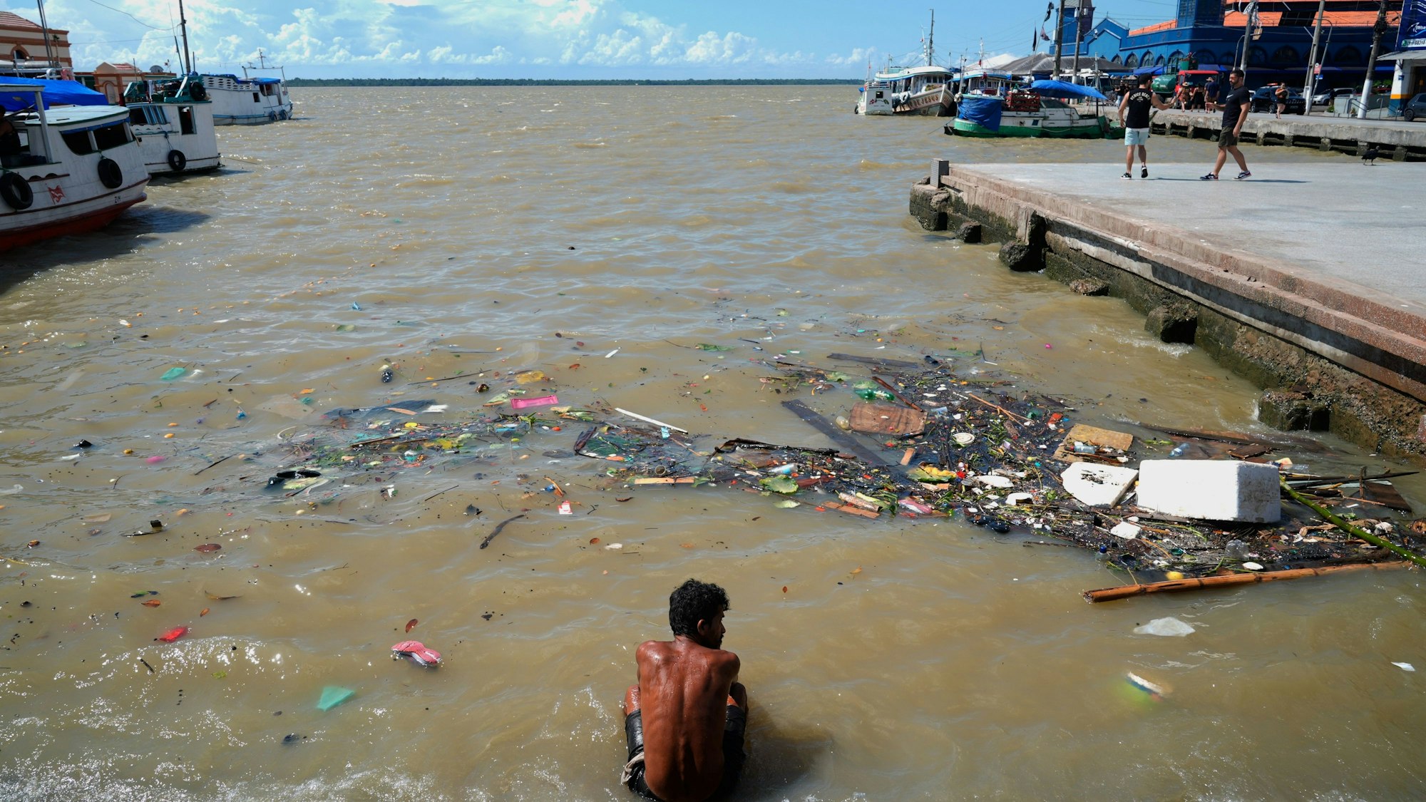 08.11.2025, Brasilien, Belem: Ein Mann sitzt an einem Fluss nahe des Veranstraltungsortes des COP30-Klimagipfels. Der Klimagipfel beginnt am 11. November. Foto: Fernando Llano/AP/dpa +++ dpa-Bildfunk +++