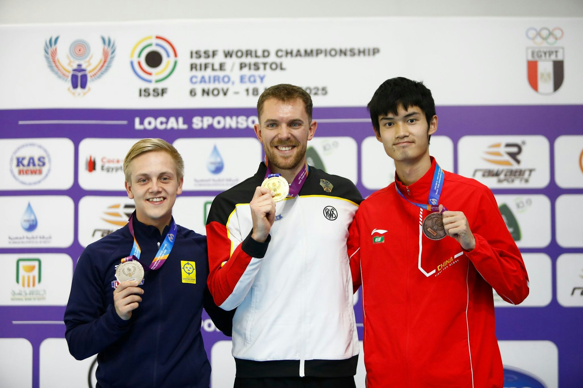 Maximilian Dallinger (M) holt überraschend WM-Gold mit dem Luftgewehr.