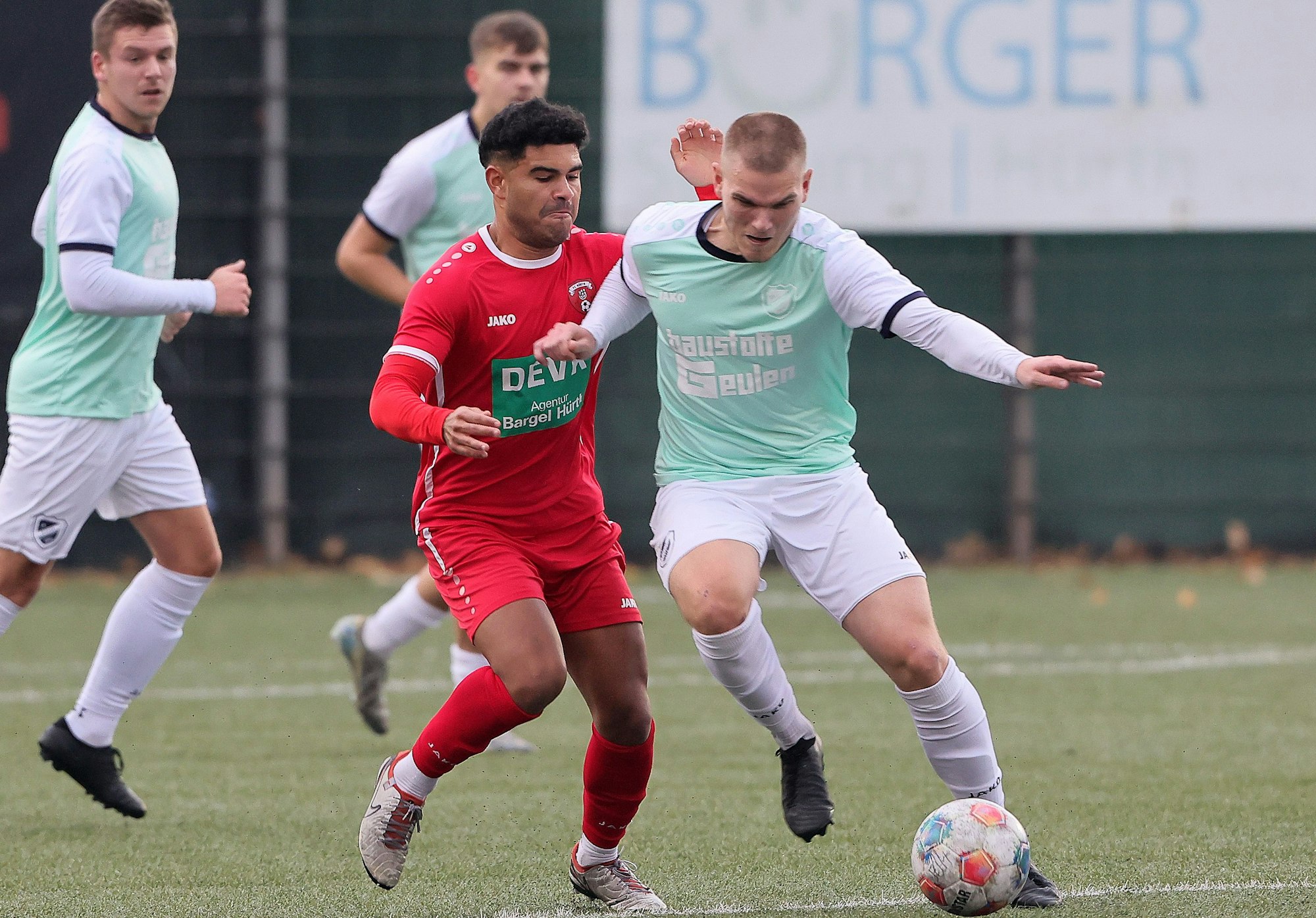 Das Bild zeigt einen Hürther Fußballer, der seinen Gegenspieler im Kampf um den Ball bedrängt.