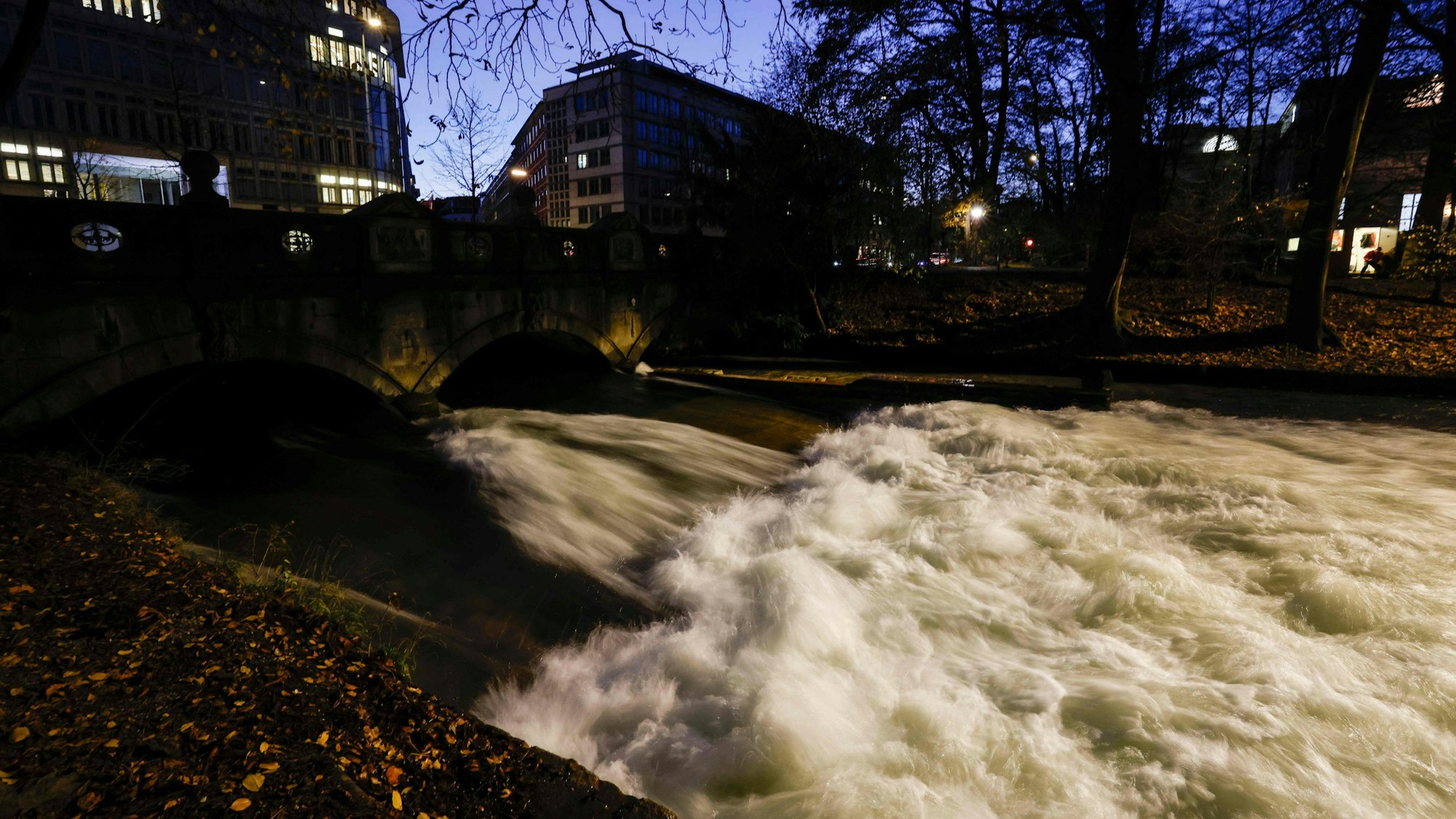 Die Eisbachwelle bei Nacht in München.