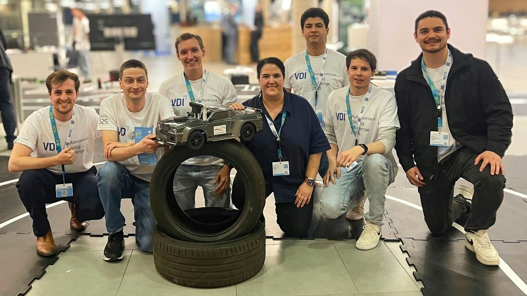 Eine Gruppe posiert mit einem ferngesteuerten Auto.