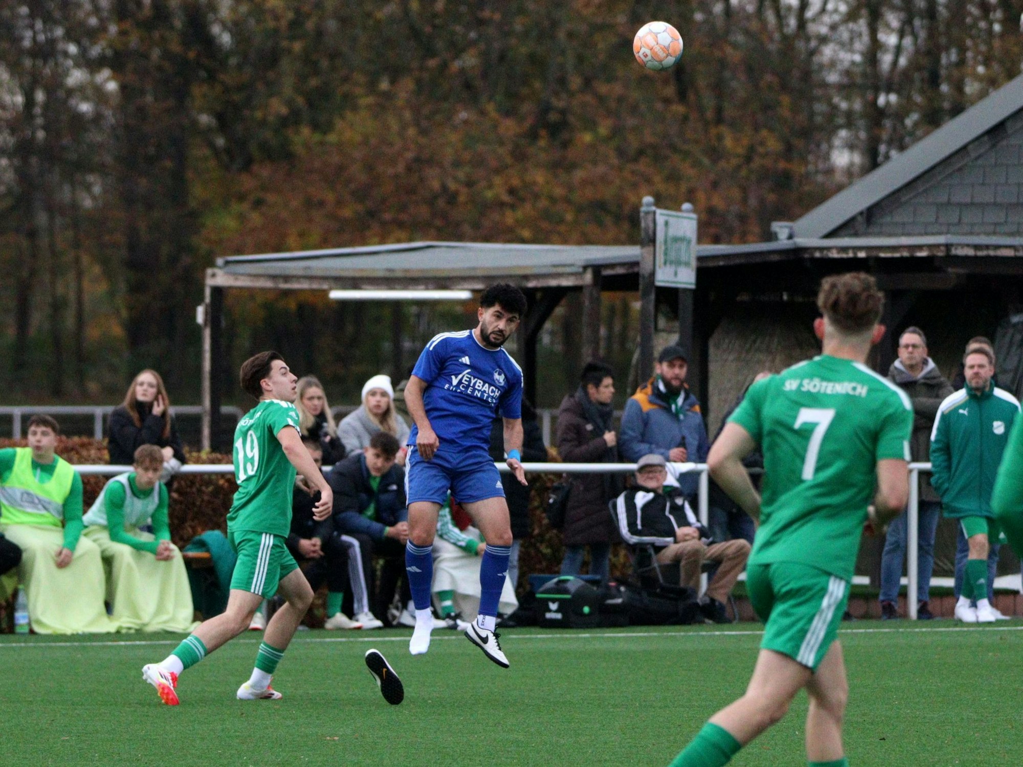 Weilerswists Spieler Solehi Salohidin steigt zum Kopfball hoch. Ein Schuh hat sich gelöst und landet auf dem Rasen.