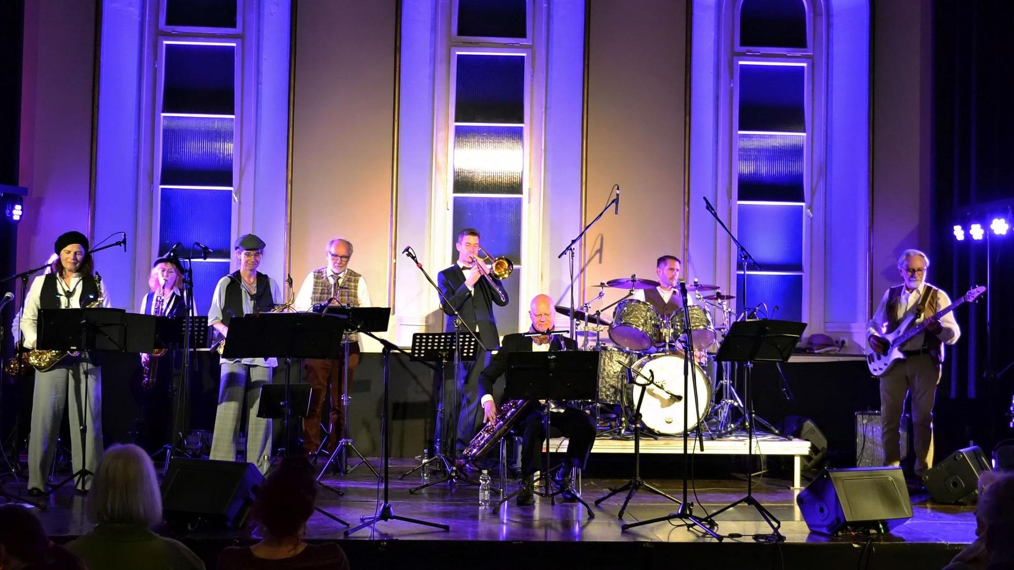 Die Jazzmusiker stehen auf der Bühne.