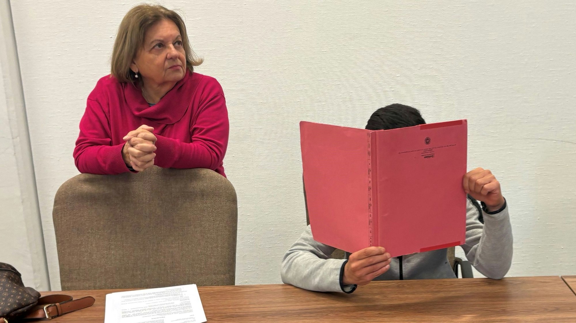 Der geständige Einbrecher mit einer Dolmetscherin beim Prozessauftakt im Kölner Landgericht