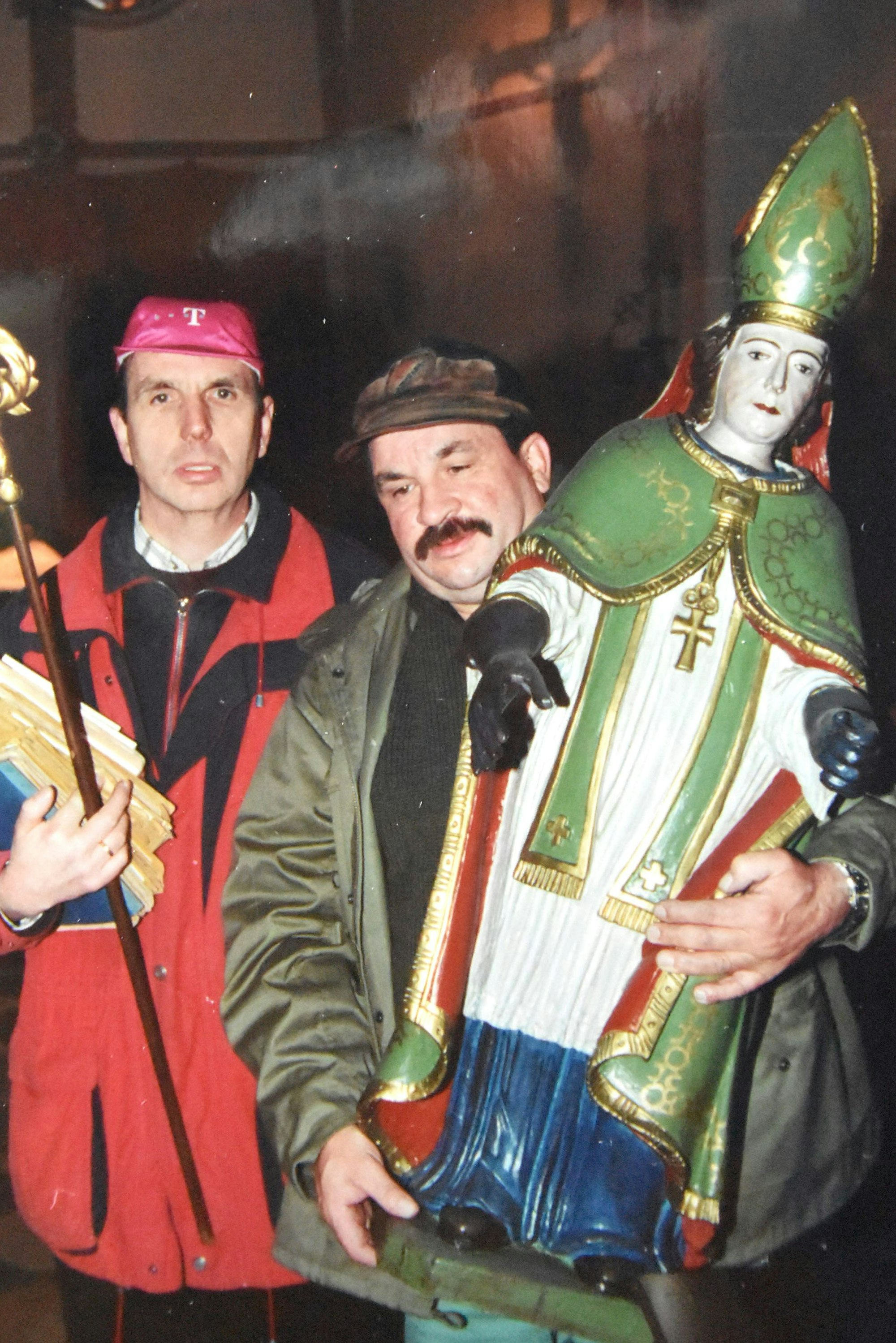 Das Bild zeigt Otto Hoffmann und Hermann-Josef Kaiser, die die Figur des heiligen Hubertus aus der Kirche tragen und nach Neu-Etzweiler bringen.