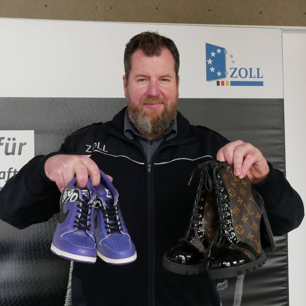 Zoll-Sprecher Jens Ahland hält gefälschte Schuhe in Händen.