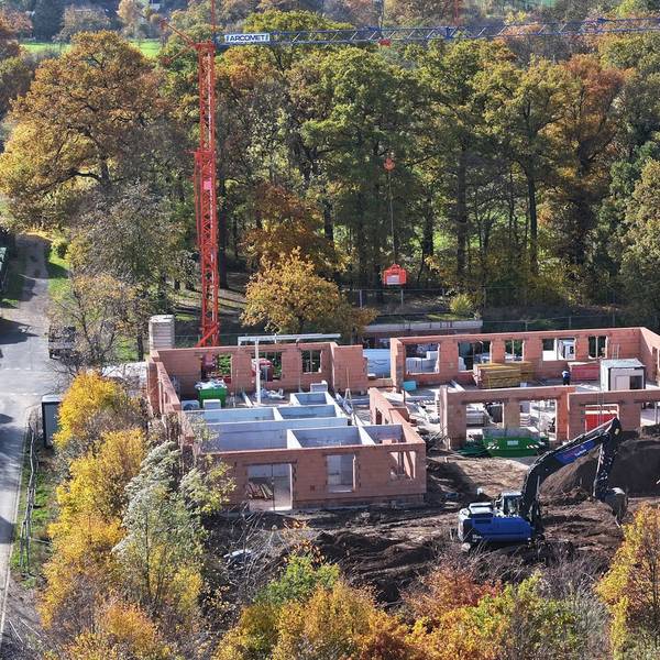 Eine Drohnenaufnahme von Baustelle, auf der die Außenmauern der Kita bereits stehen.