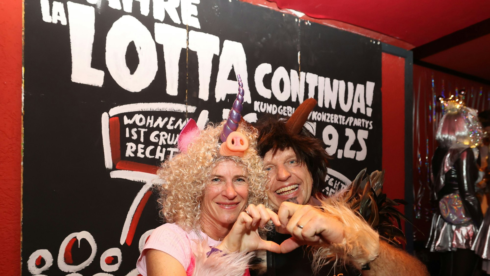 Zwei verkleidete Personen vor dem Lotta-Schild in der Kneipe in Köln.