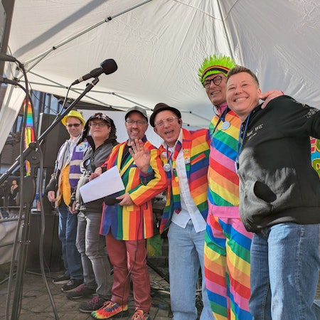 Sechs karnevalistisch verkleidete Menschen schunkeln.