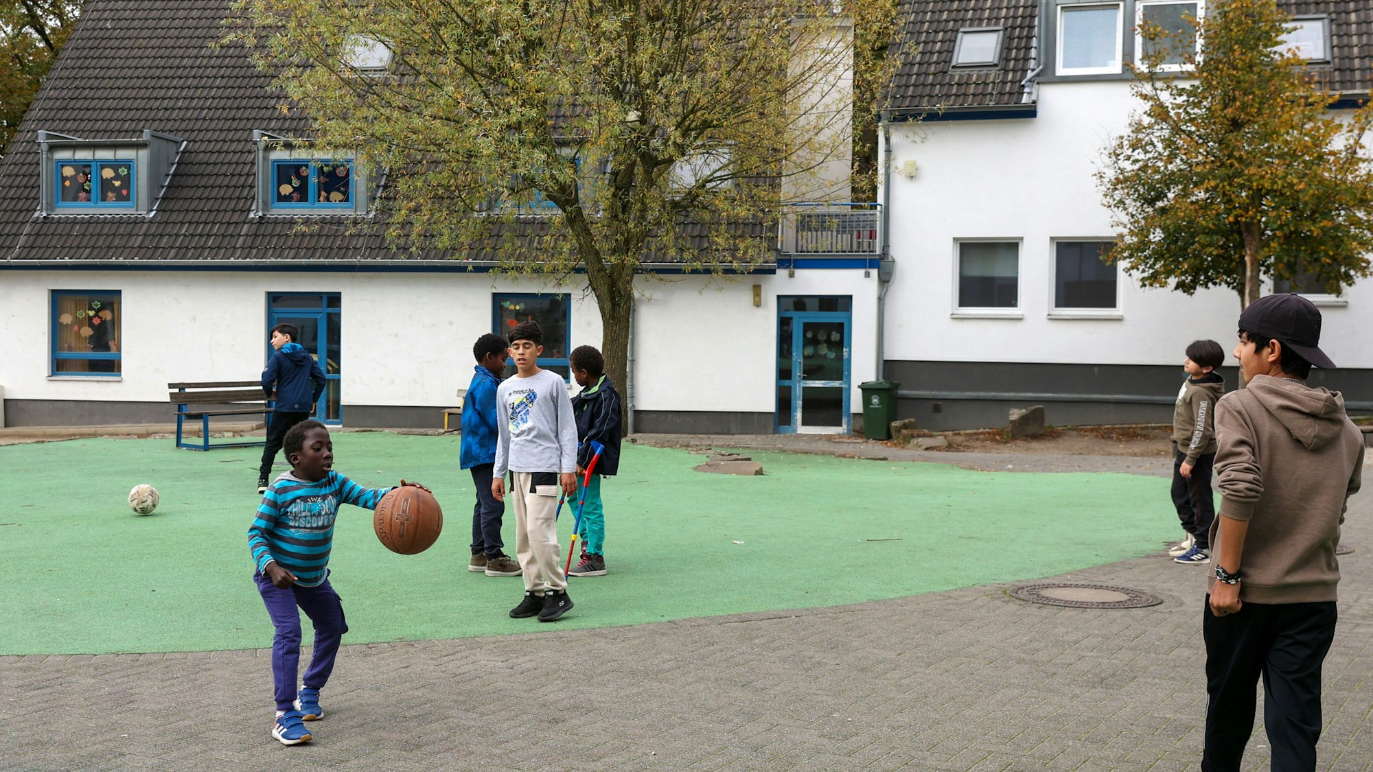 Jungs auf einer Freifläche zwischen den Gebäuden kicken.