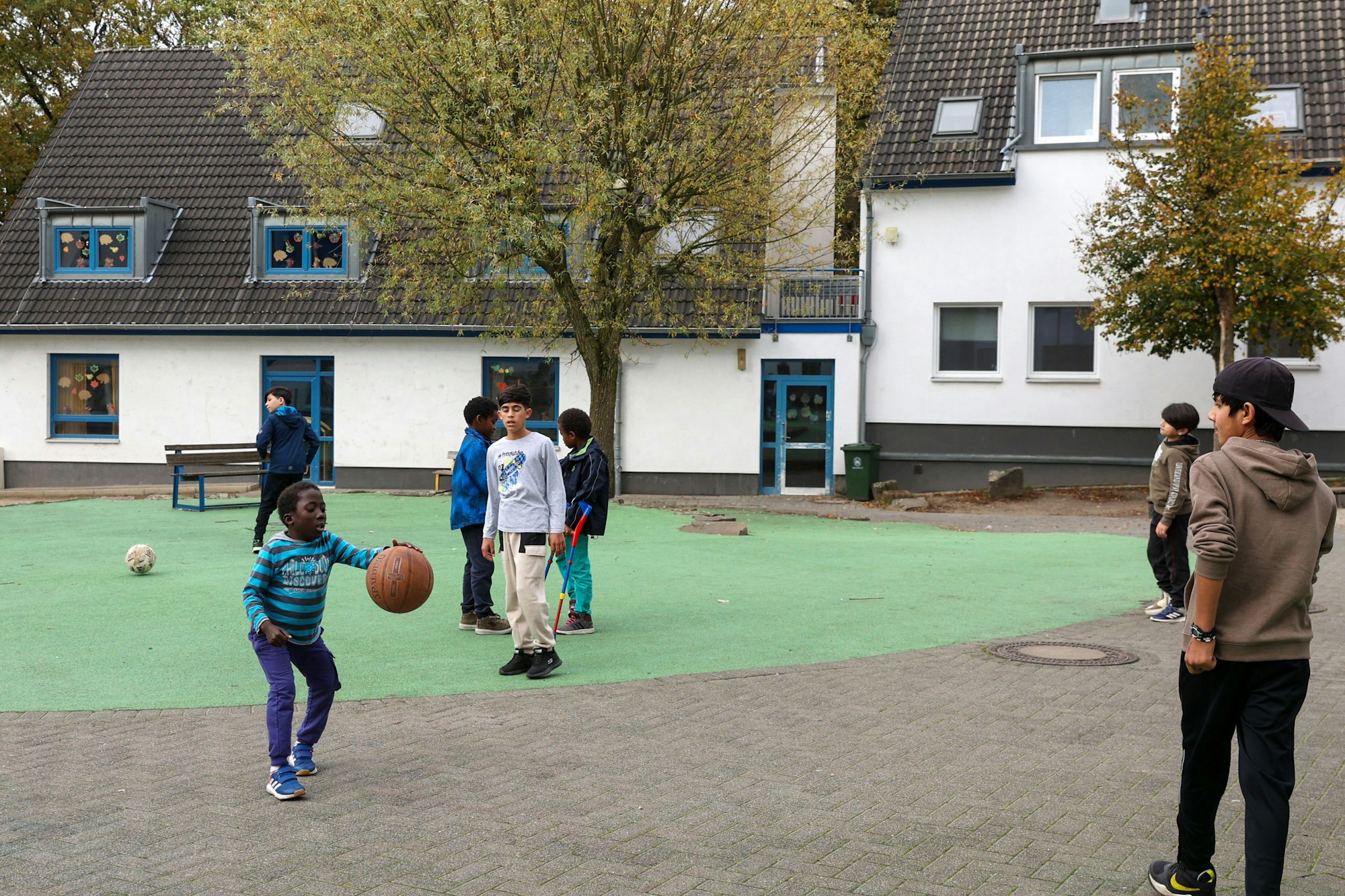 Jungs auf einer Freifläche zwischen den Gebäuden kicken.