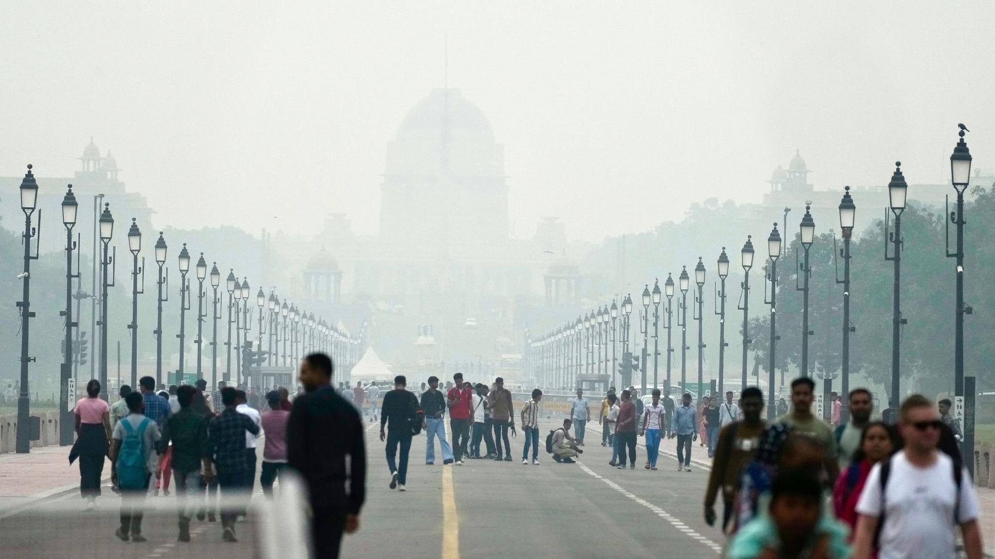 Menschen auf einer in Smog gehüllten Straße in Neu Delhi.