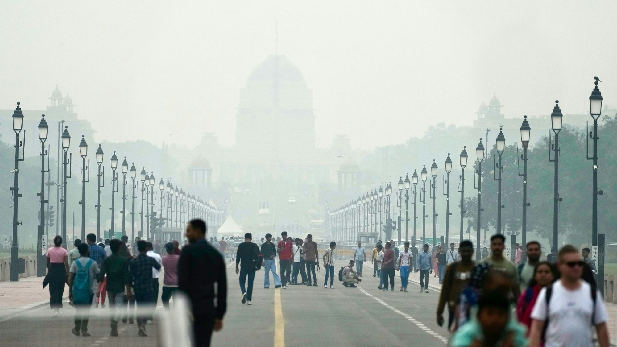 Menschen auf einer in Smog gehüllten Straße in Neu Delhi.