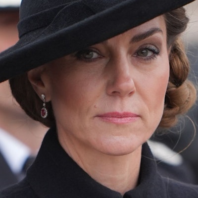 Prinzessin Kate mit ernstem Blick und schwarzem Hut.