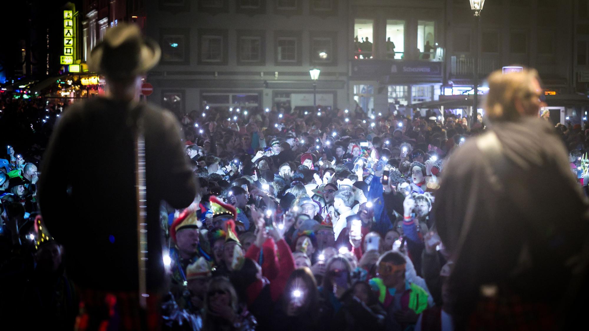 Das Bild zeigt Fans die ihre Handylichter bei einem Konzert der Kölner Band Brings in der Düsseldorfer Altstadt in die Höhe halten. Foto: Christoph Reichwein/dpa
