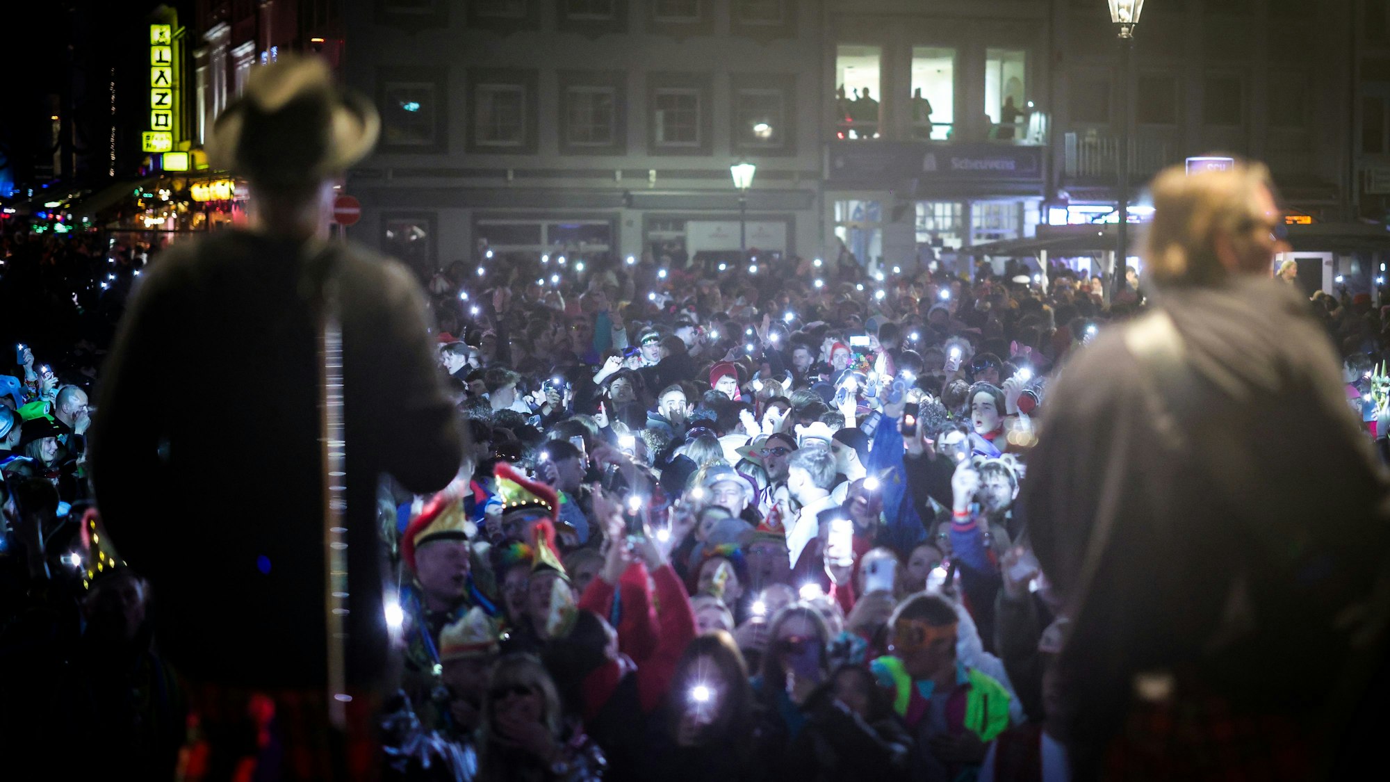 Das Bild zeigt Fans die ihre Handylichter bei einem Konzert der Kölner Band Brings in der Düsseldorfer Altstadt in die Höhe halten. Foto: Christoph Reichwein/dpa