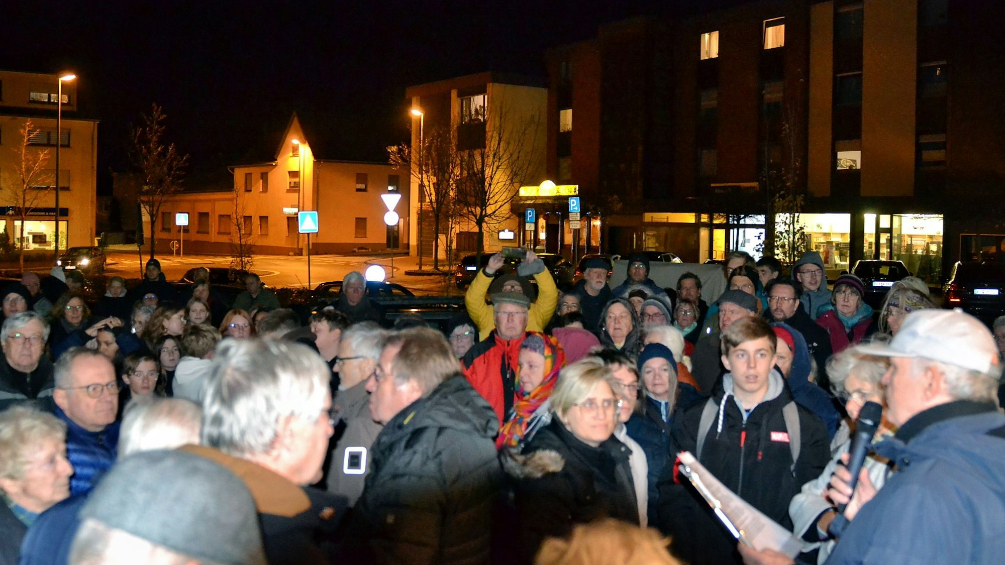 Eine große Gruppe Menschen hat sich um einen Redner versammelt.