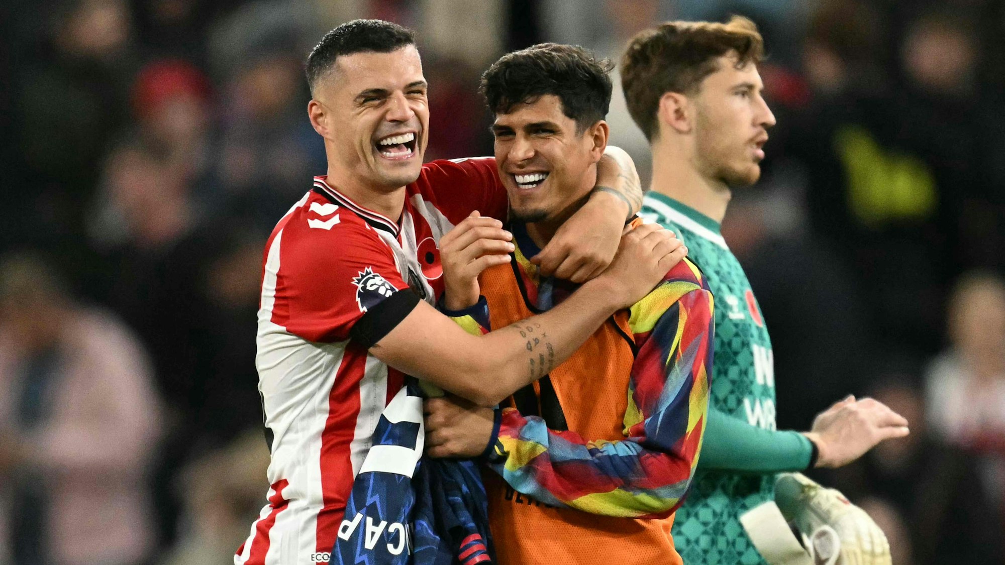 TOPSHOT - Sunderland's Swiss midfielder #34 Granit Xhaka (L) jokes with Arsenal's Ecuadorian defender #05 Piero Hincapie (R) after the final whistle during the English Premier League football match between Sunderland and Arsenal at The Stadium of Light in Sunderland in north east England on November 8, 2025. (Photo by Oli SCARFF / AFP) / RESTRICTED TO EDITORIAL USE. No use with unauthorized audio, video, data, fixture lists, club/league logos or 'live' services. Online in-match use limited to 120 images. An additional 40 images may be used in extra time. No video emulation. Social media in-match use limited to 120 images. An additional 40 images may be used in extra time. No use in betting publications, games or single club/league/player publications. /