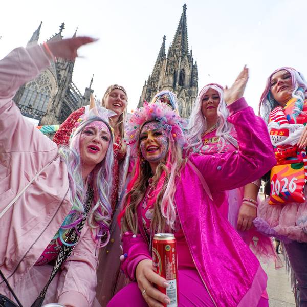 Jecken aus der Eifel stehen zum Beginn der Karnevalssession vor dem Dom für ein Foto zusammen.