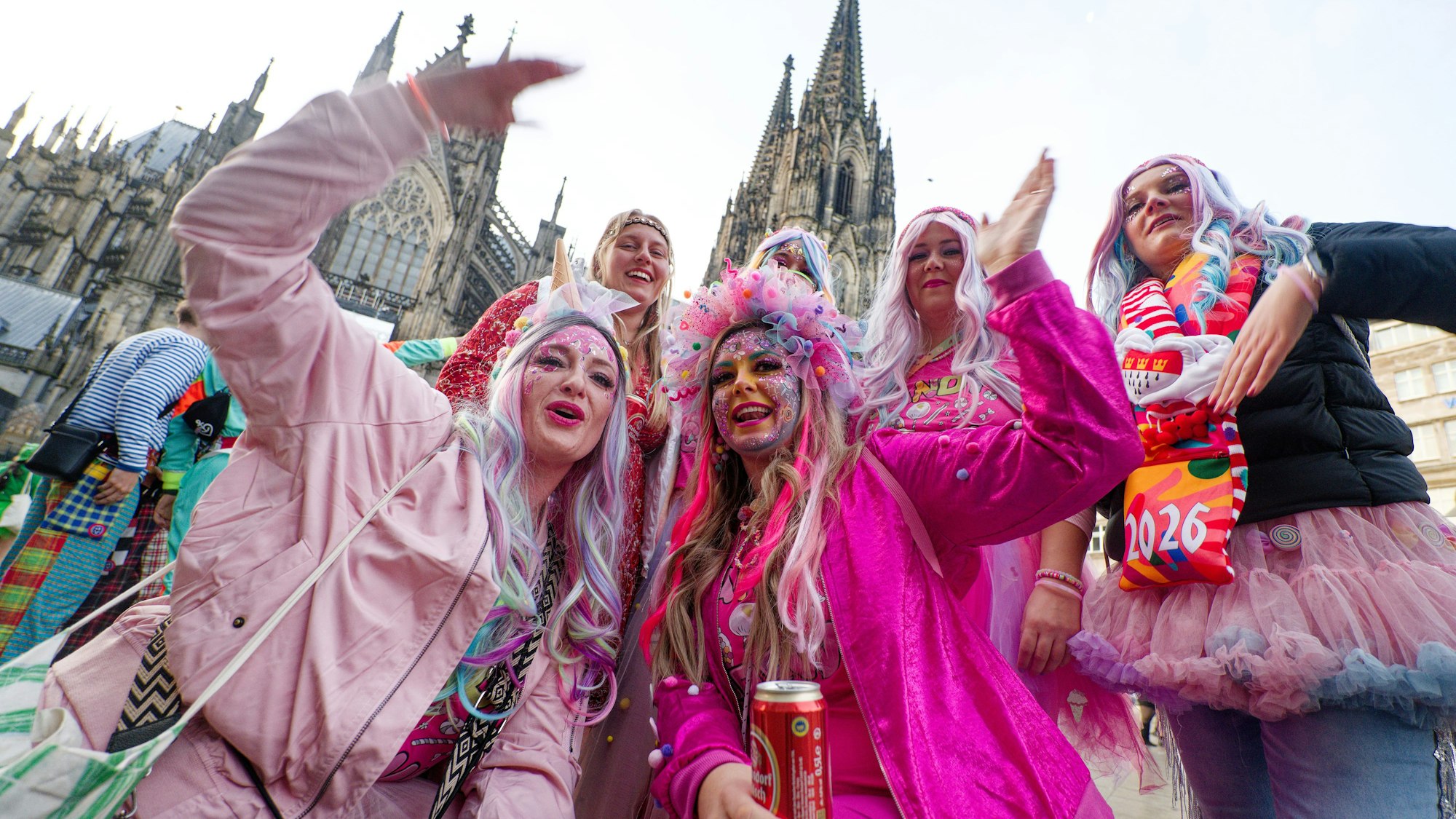 Jecken aus der Eifel stehen zum Beginn der Karnevalssession vor dem Dom für ein Foto zusammen.