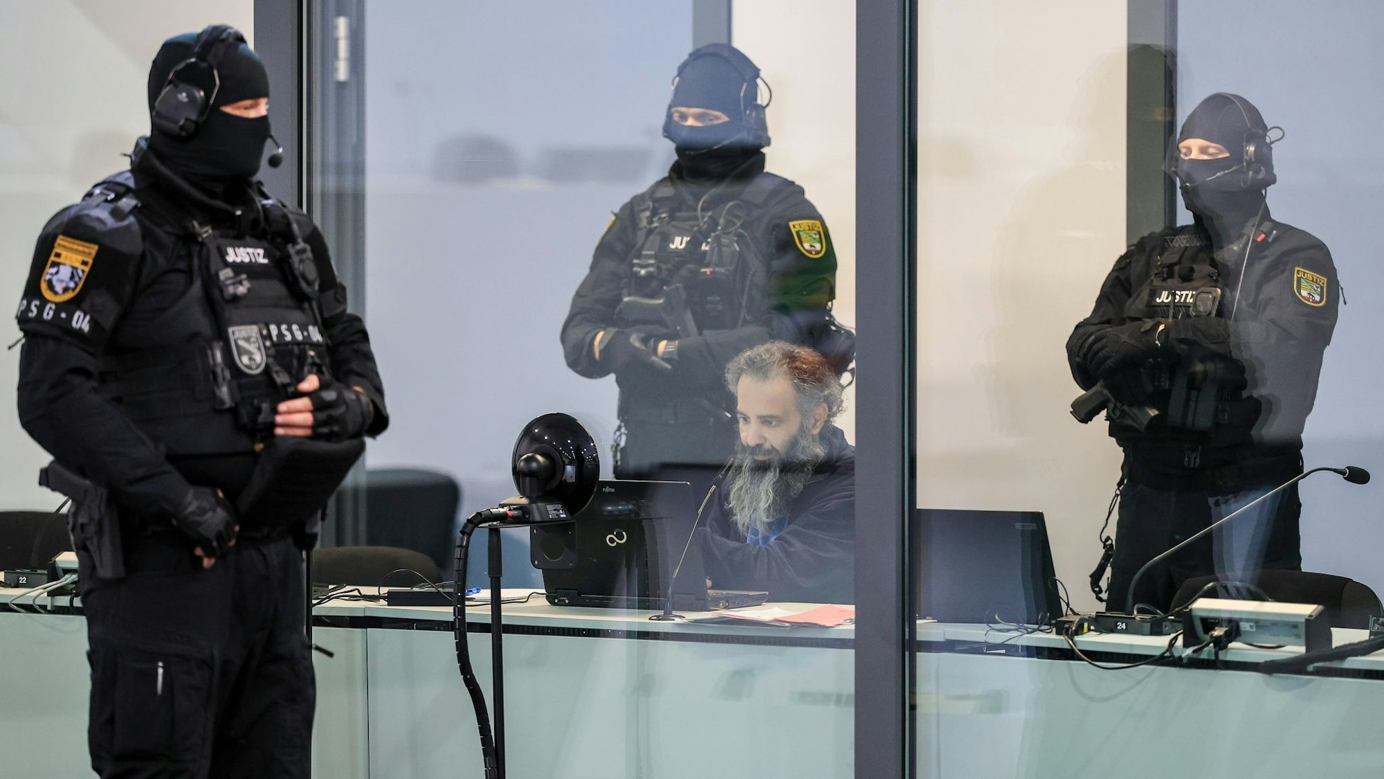 Der Angeklagte Taleb al-Abdulmohsen sitzt mit Handfesseln in dem kugelsicheren Glaskasten im temporären Gerichtsgebäude.