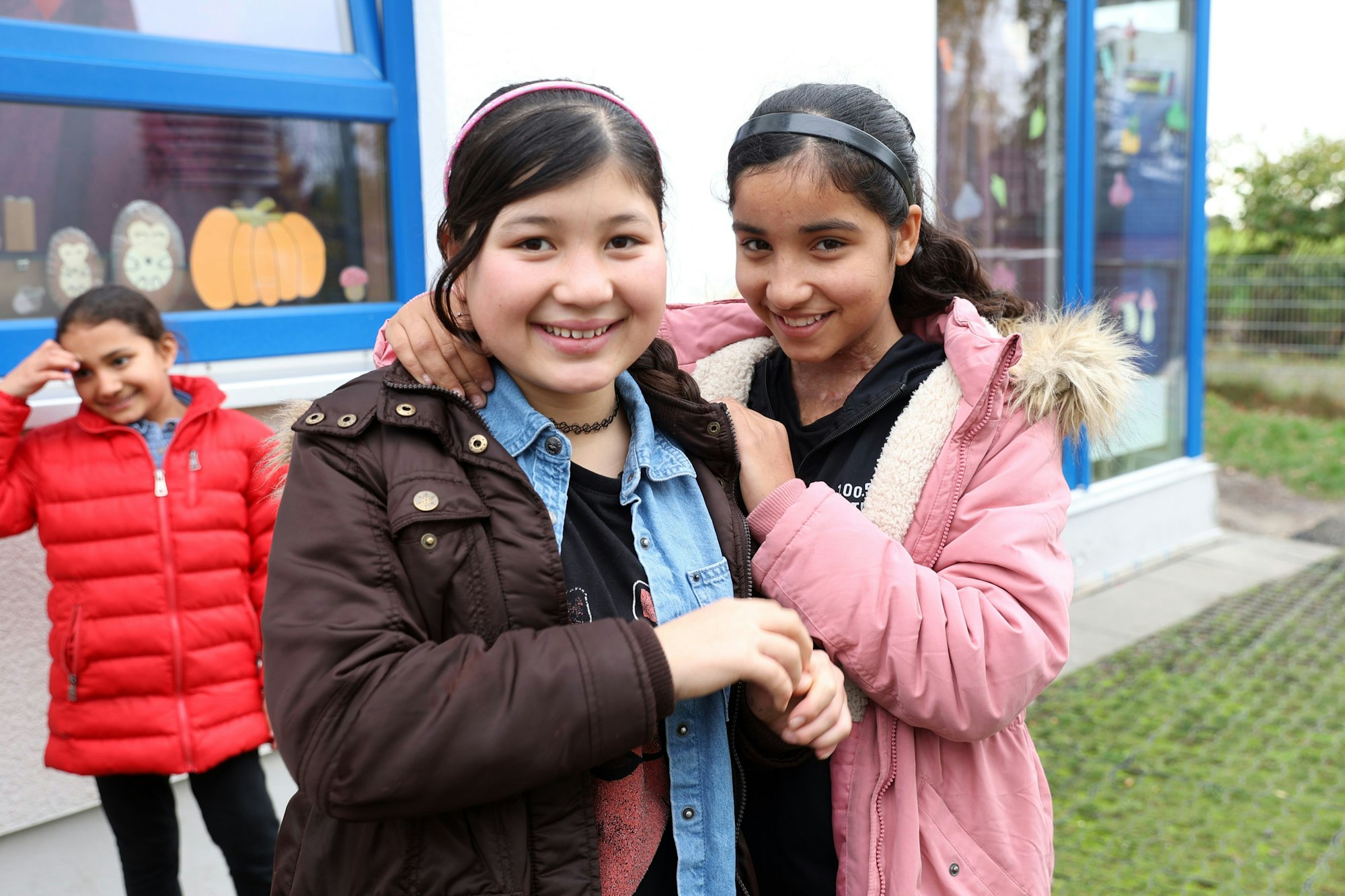 Masuda und Tina aus Afghanistan stehen auf dem Hof des Friedensdorf.