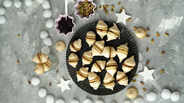 Durch die Geleefüllung werden zwei Vanillekipferl miteinander verbunden. Dann bekommt der Doppel-Keks auch noch zwei Zipfelmützchen in Form von Baiserhauben.