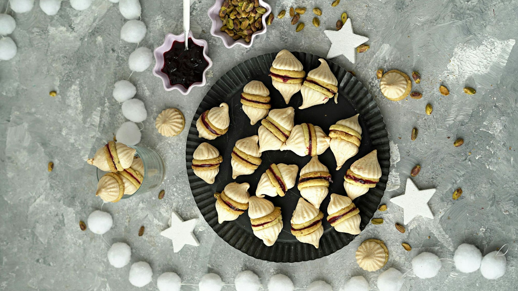 Durch die Geleefüllung werden zwei Vanillekipferl miteinander verbunden. Dann bekommt der Doppel-Keks auch noch zwei Zipfelmützchen in Form von Baiserhauben.