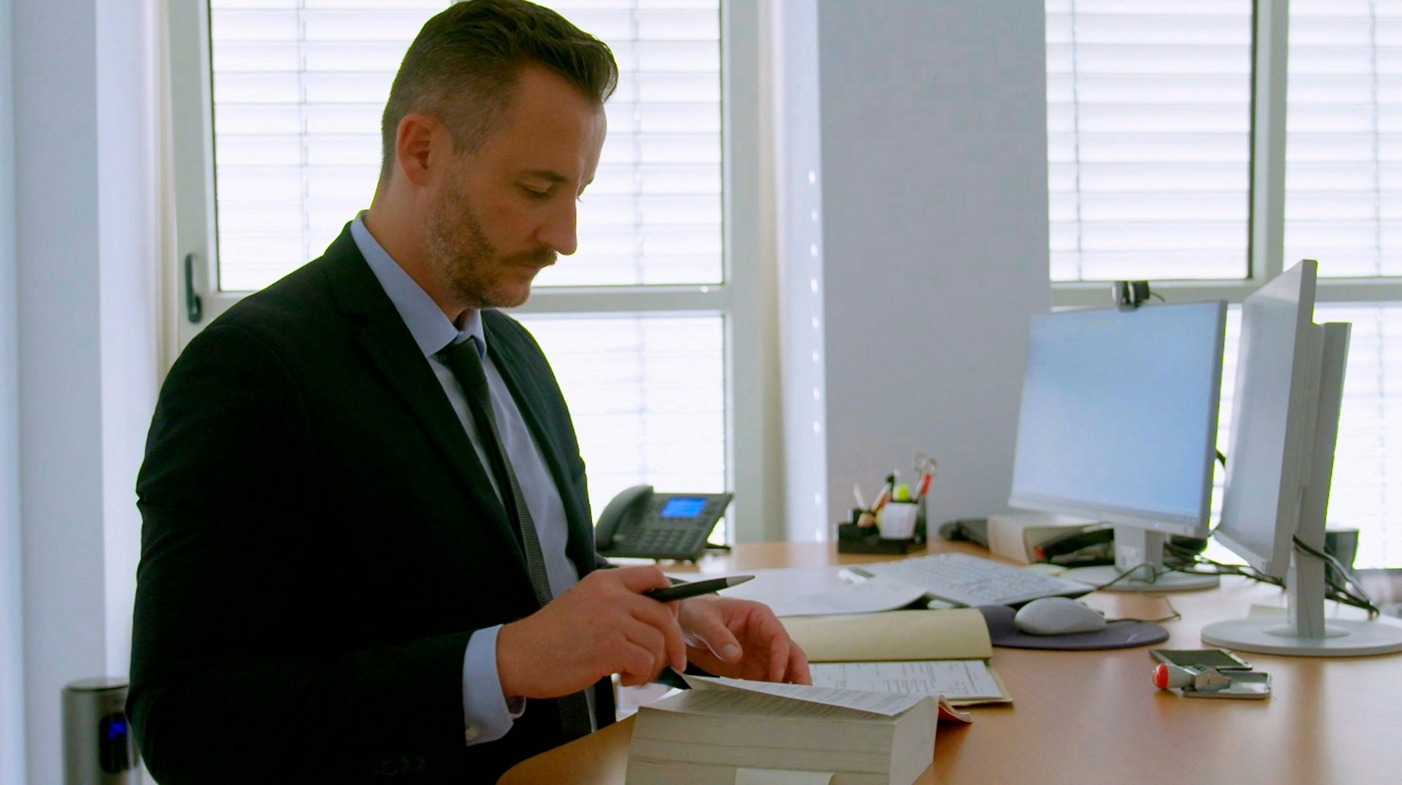 Oberstaatsanwalt Thomas Hauburger schaut in ein Buch.