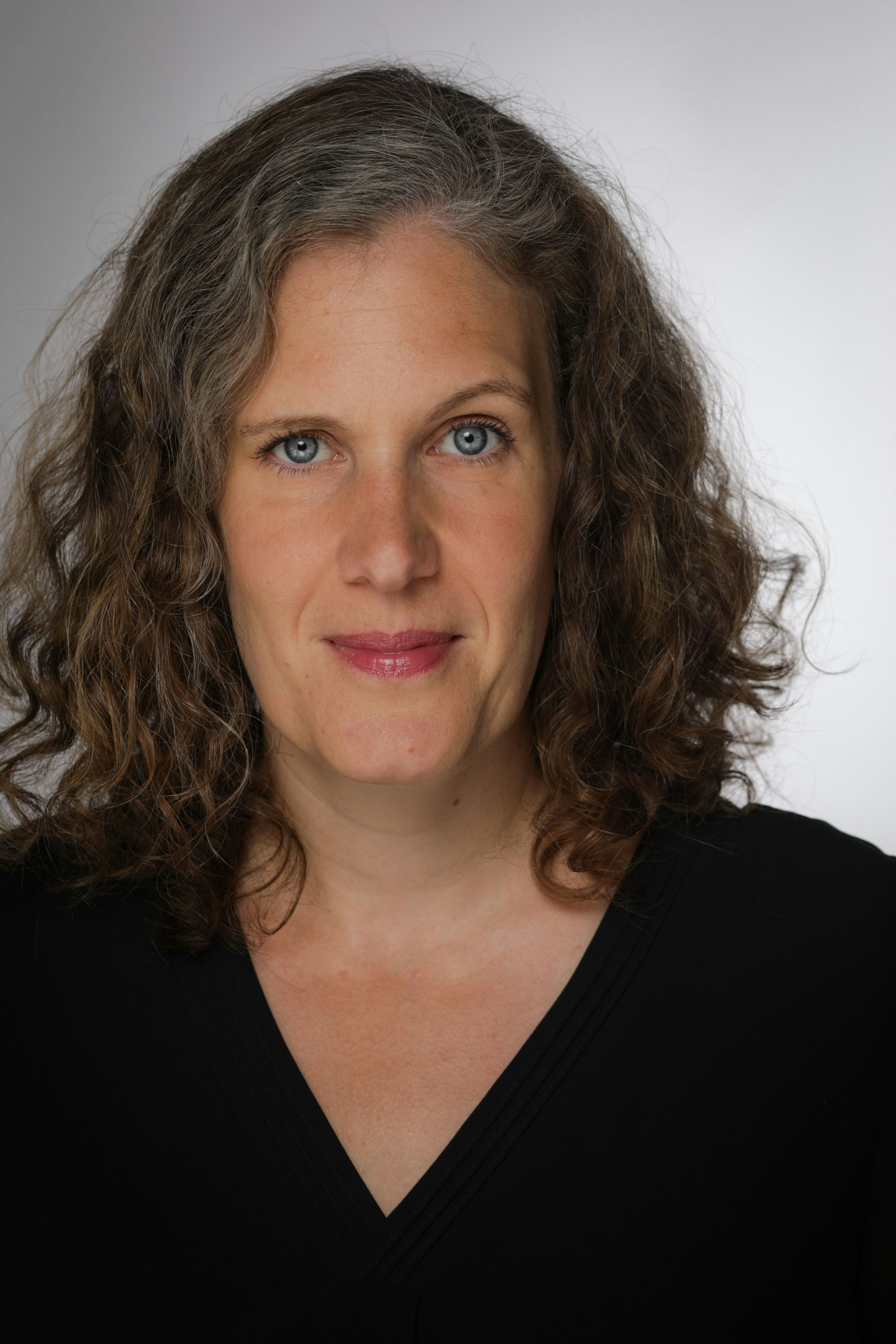 Eine Frau mit braunen Locken schaut in die Kamera. Foto: Henrike Schecke