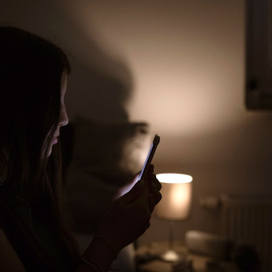 Ein Mädchen schaut auf ein Handy.