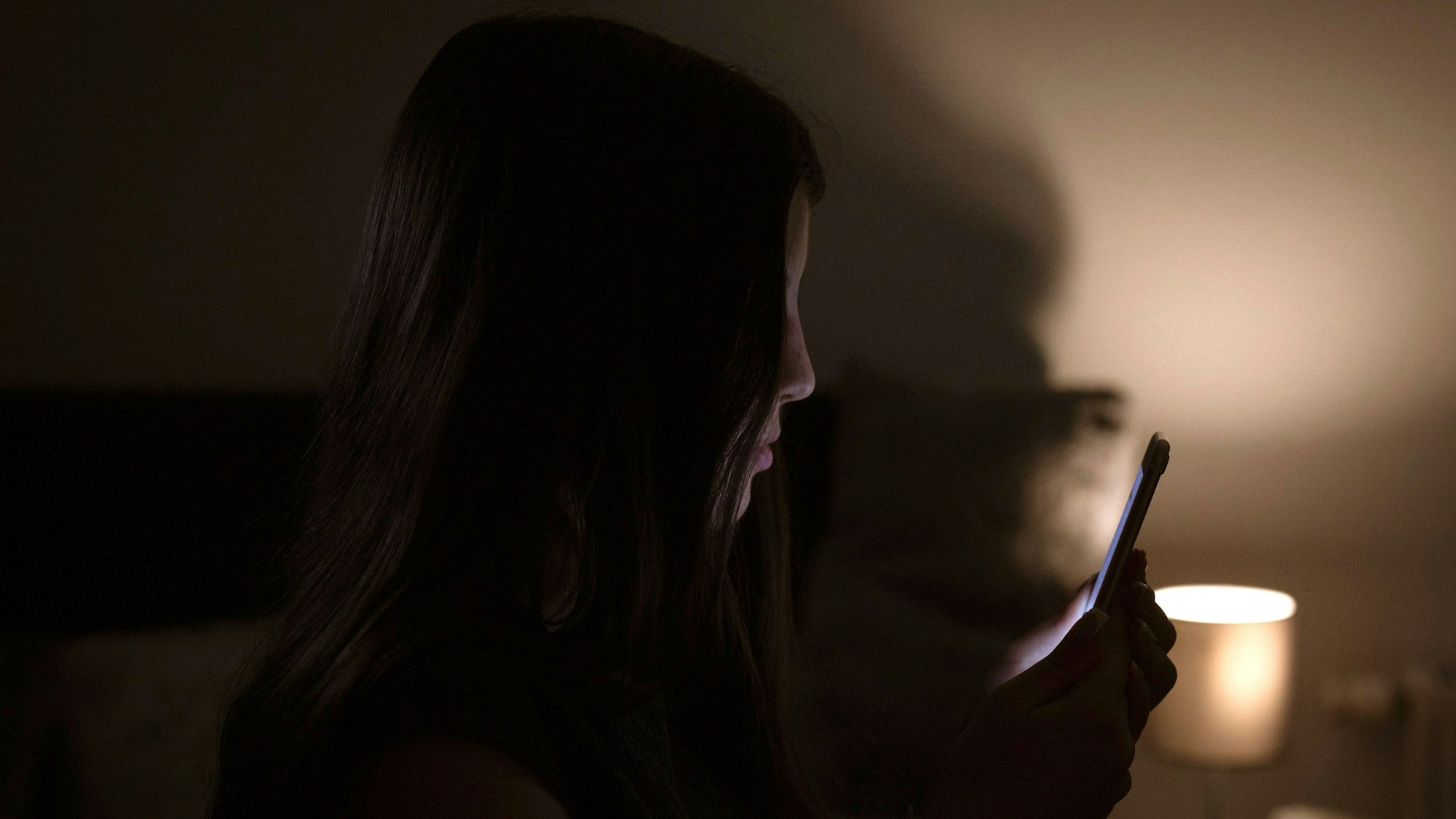 Ein Mädchen schaut auf ein Handy.