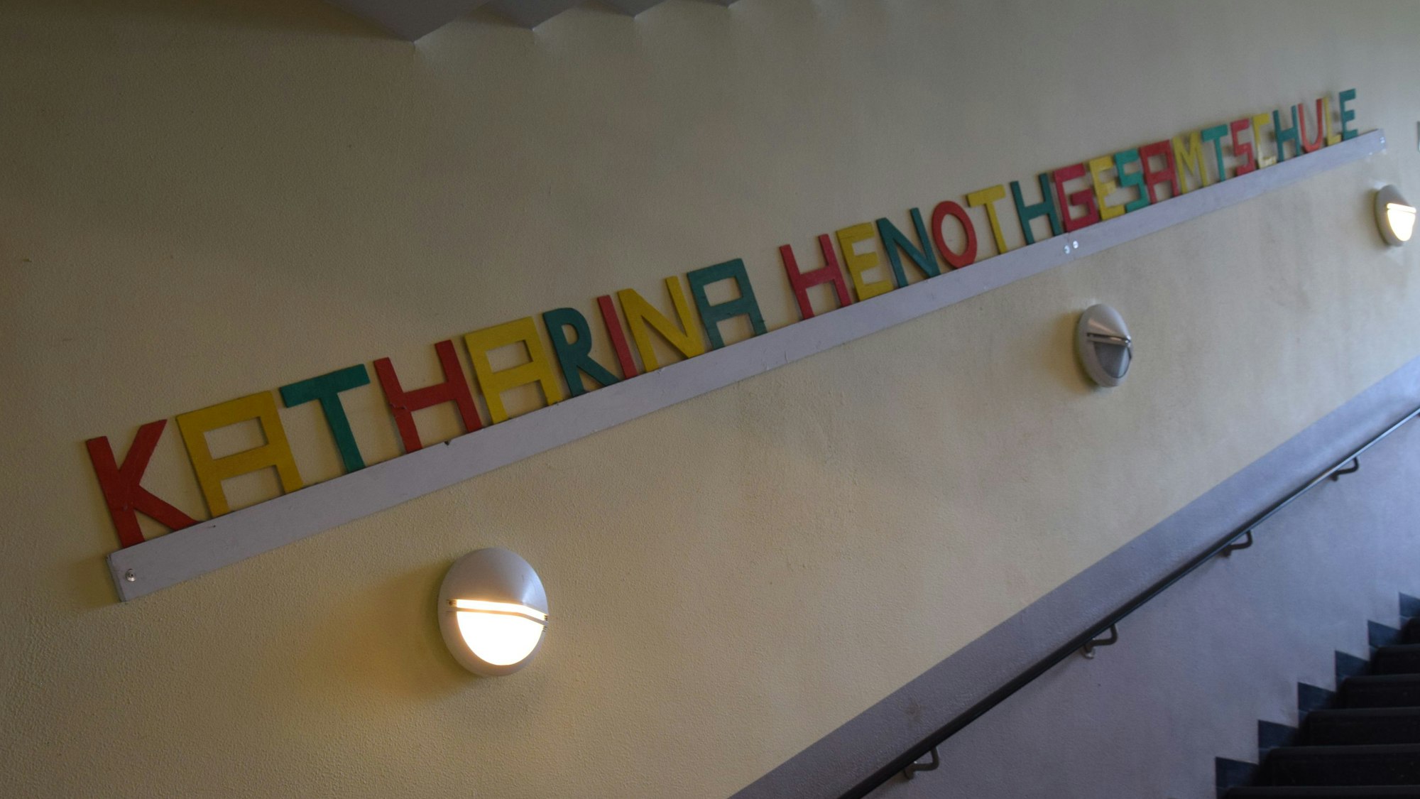 Der Schriftzug Katharina-Henoth-Gesamtschule hängt in bunten Lettern an einer Schulwand.