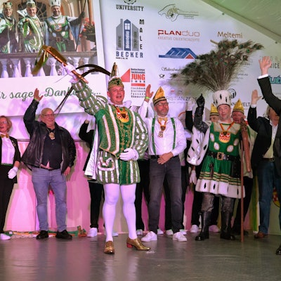 Auf der Bühne in Flamersheim stehen die Tollitäten, ihr Gefolge und Bürgermeister Reichelt und heben die Hände zum Alaaf-Ruf in die Höhe.