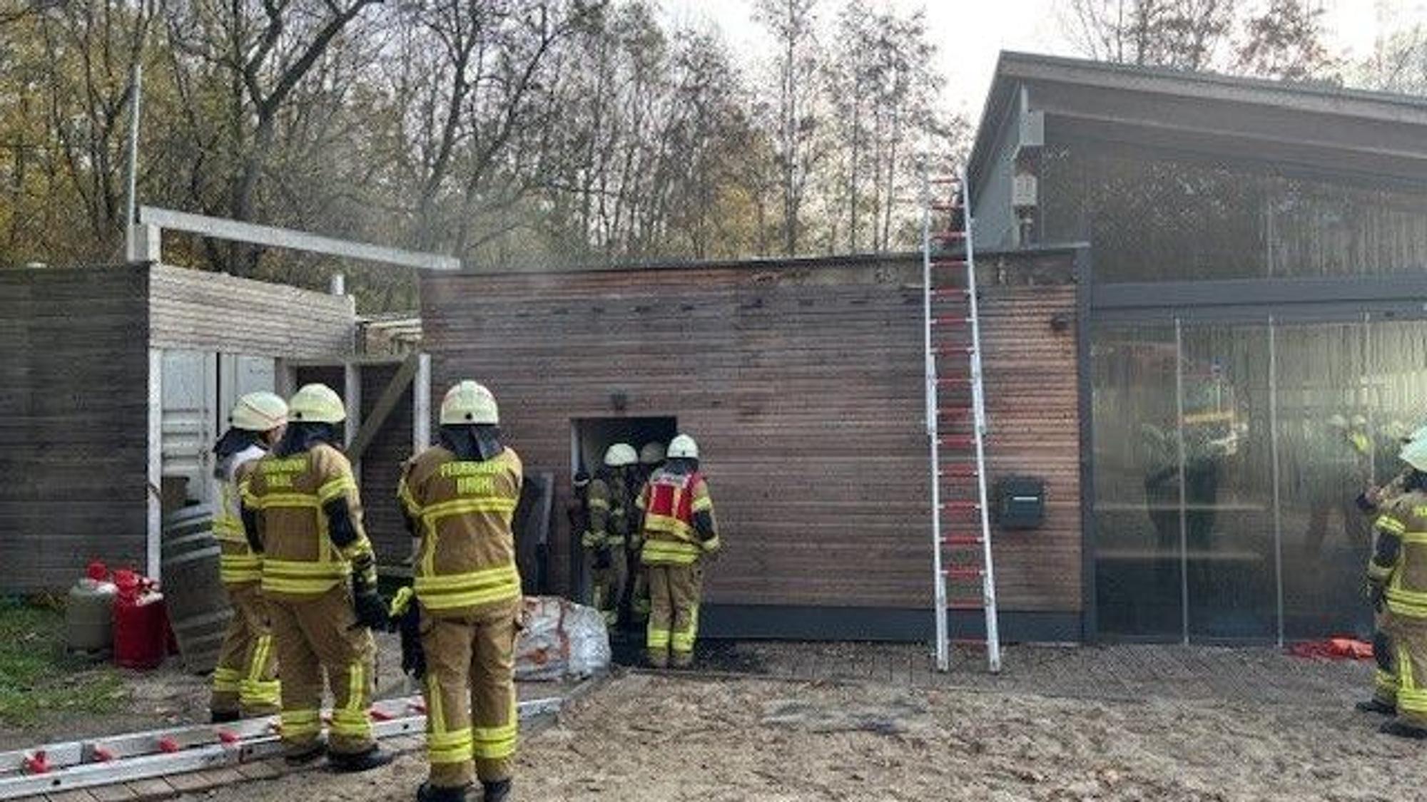 Das Bild zeigt Feuerwehrleute vor einem Strandpavillon.