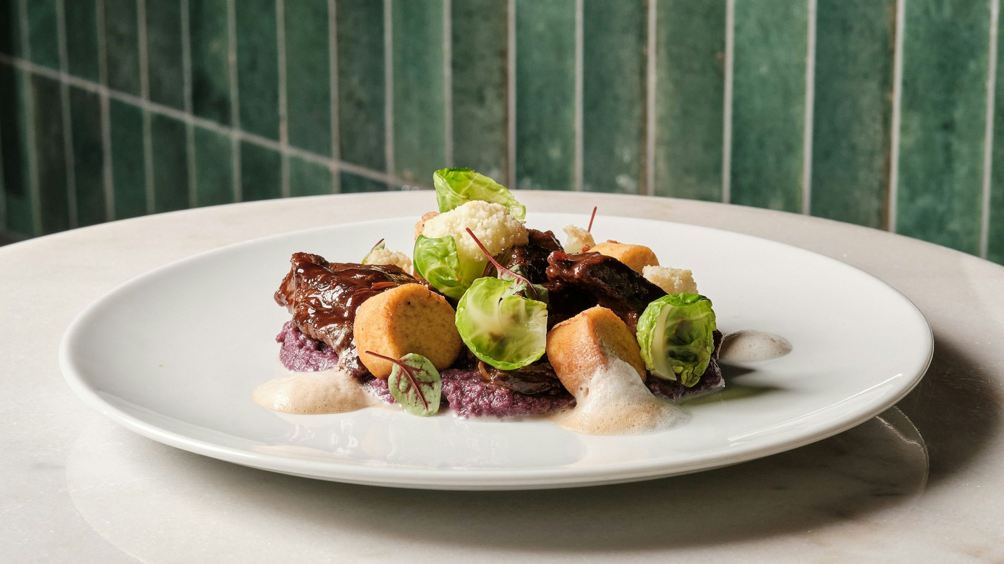 So sieht das fertige Wildgulasch mit Kartoffeltaler, Rotkohlpüree und Kaffeeschaum von Hasan Barbare aus.