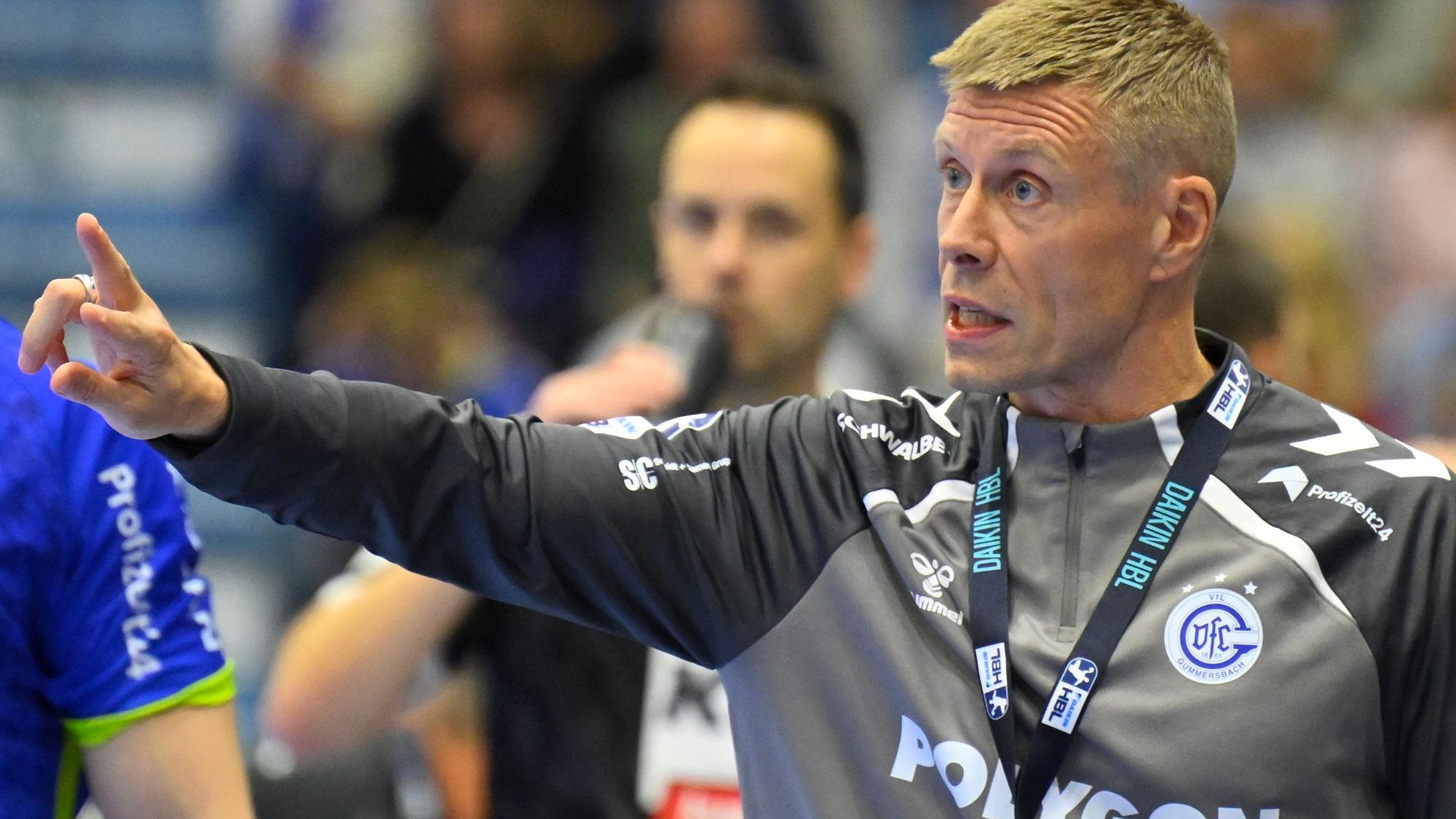 Zu sehen ist ein Handballtrainer an der Seitenlinie.