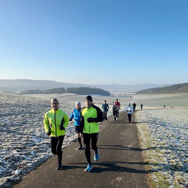 Läufen laufen im Winter über einen Feldweg, auf dem Boden ist Frost.