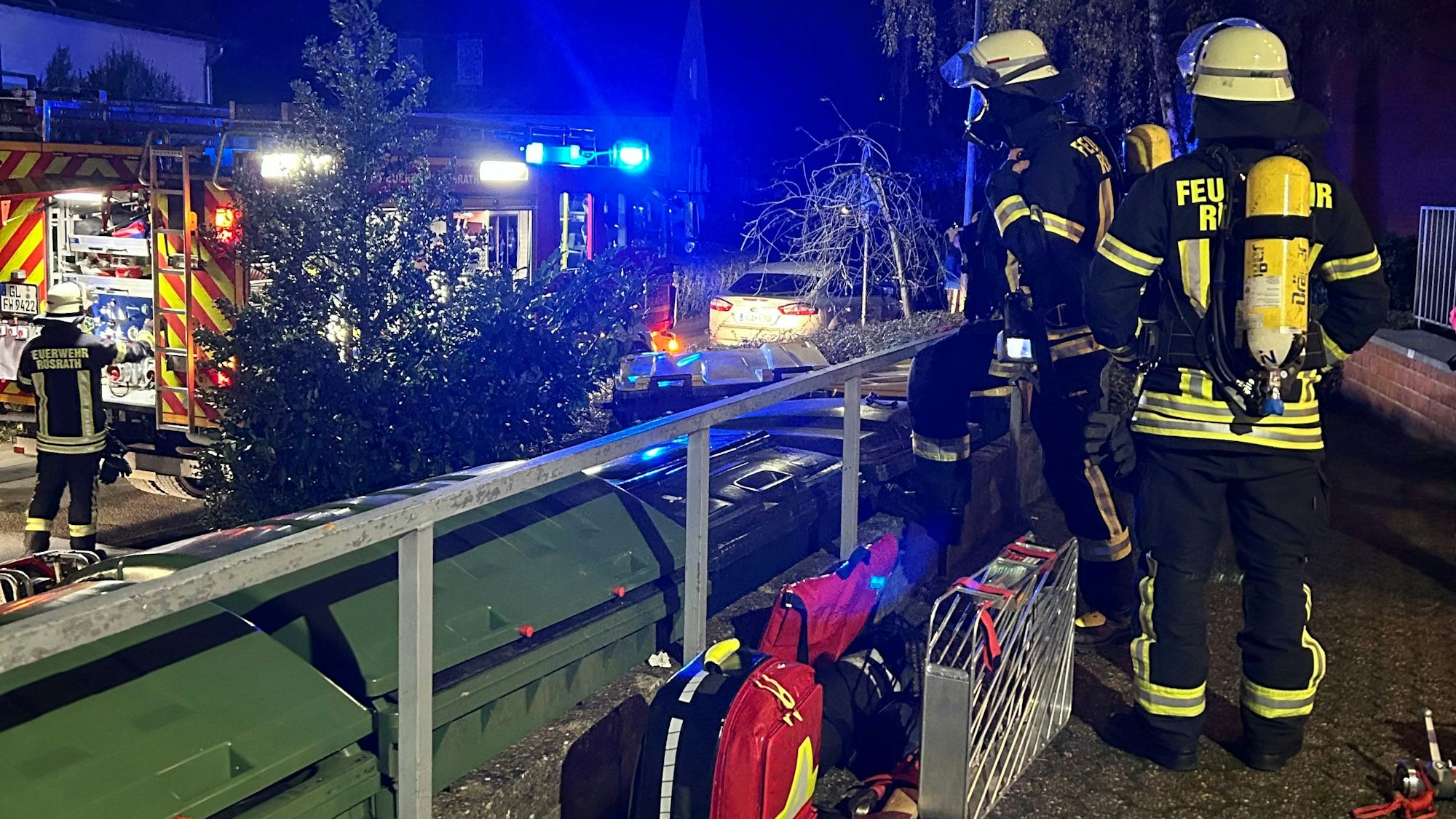 Feuerwehrleute und -einsatzkräfte stehen an einer Einsatzstelle an der Gartenstraße in Rösrath-Hoffnungsthal.