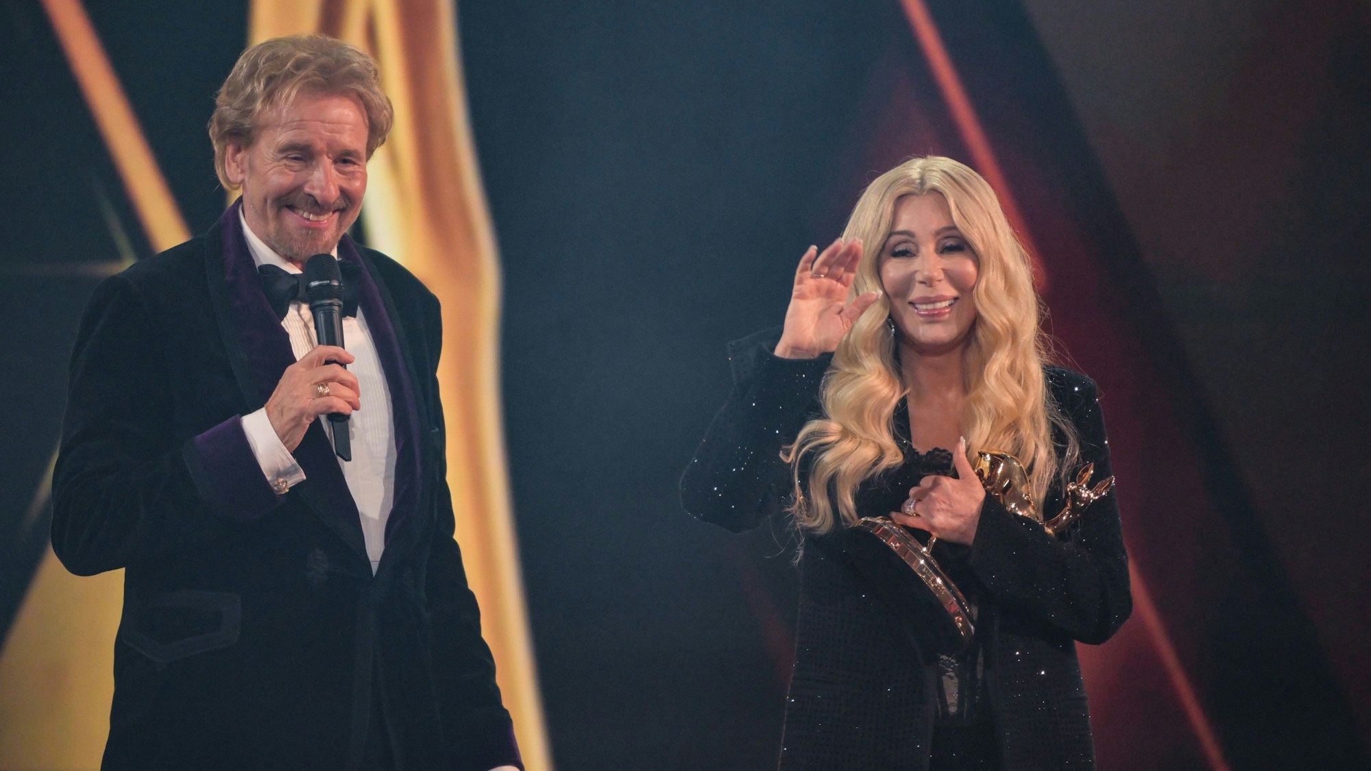 Cher winkt neben Thomas Gottschalk, nachdem sie einen Bambi in der Kategorie Legende, während der 77. Bambi-Verleihung in den Bavaria Filmstudios erhalten hat.