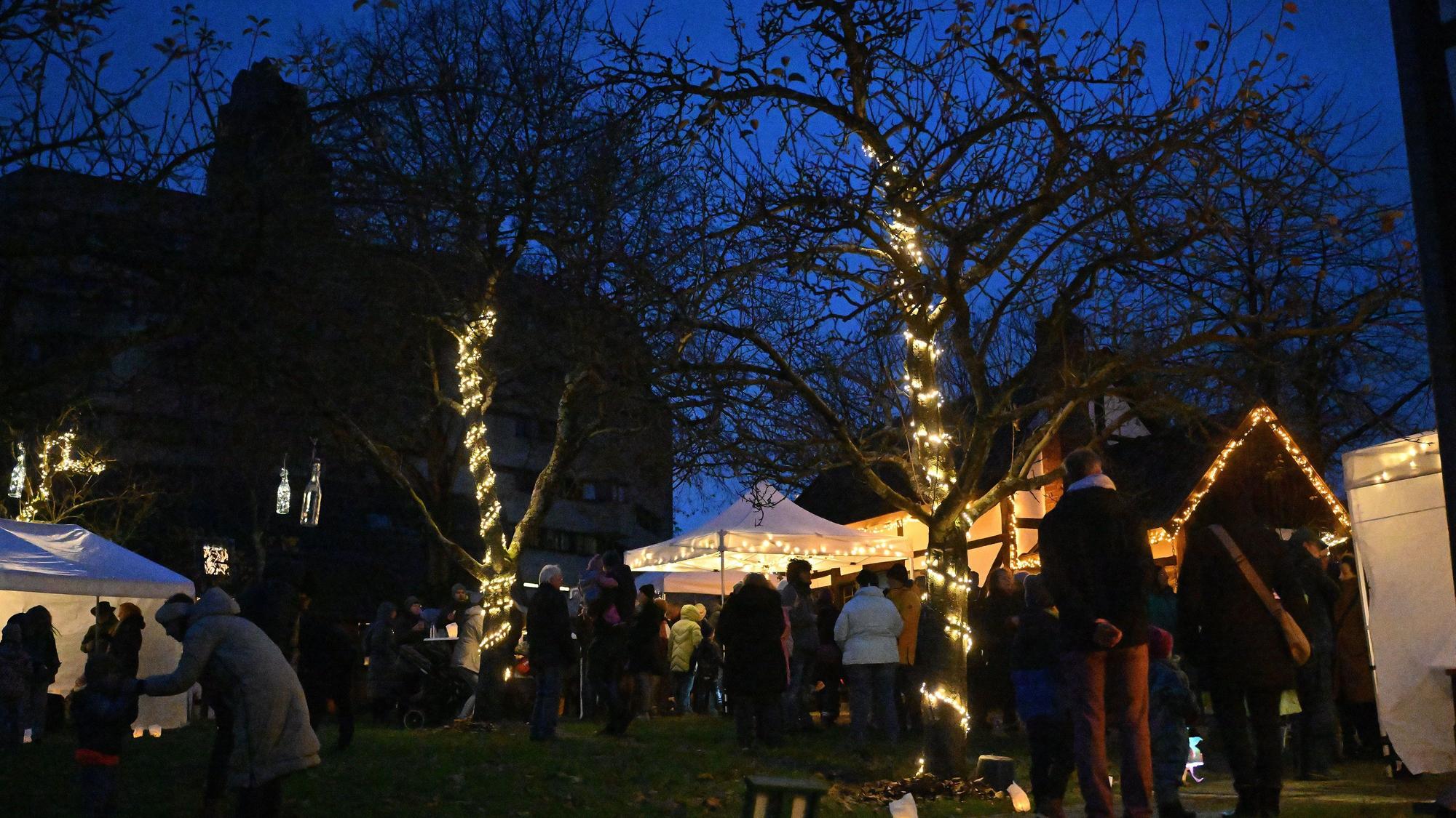 Besucher beim Lichterfest vergangenes Jahr, Häuser und Bäume sind mit Lichterketten geschmückt.