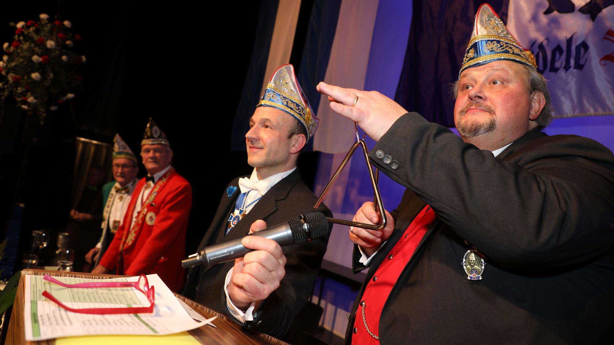 Thomas Cüpper schlägt als Sitzungspräsident der Sitzung Fastelovend Anno Pief eine Triangel an