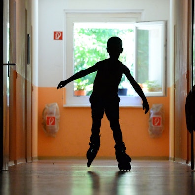 Ein Kind fährt auf dem Flur Inliner.