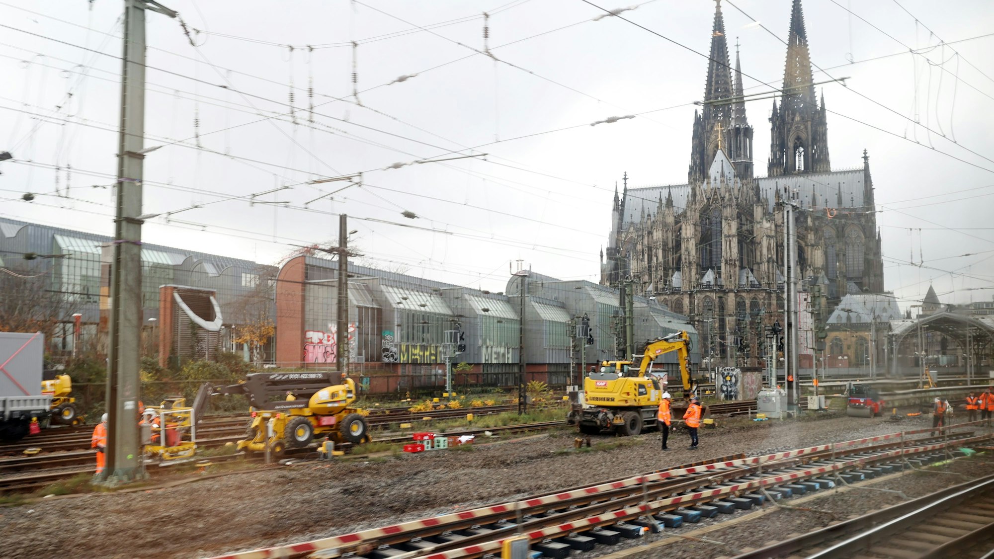 Arbeiter auf den Gleisen des Kölner Hauptbahnhofs. Im Hintergrund der Kölner Dom.