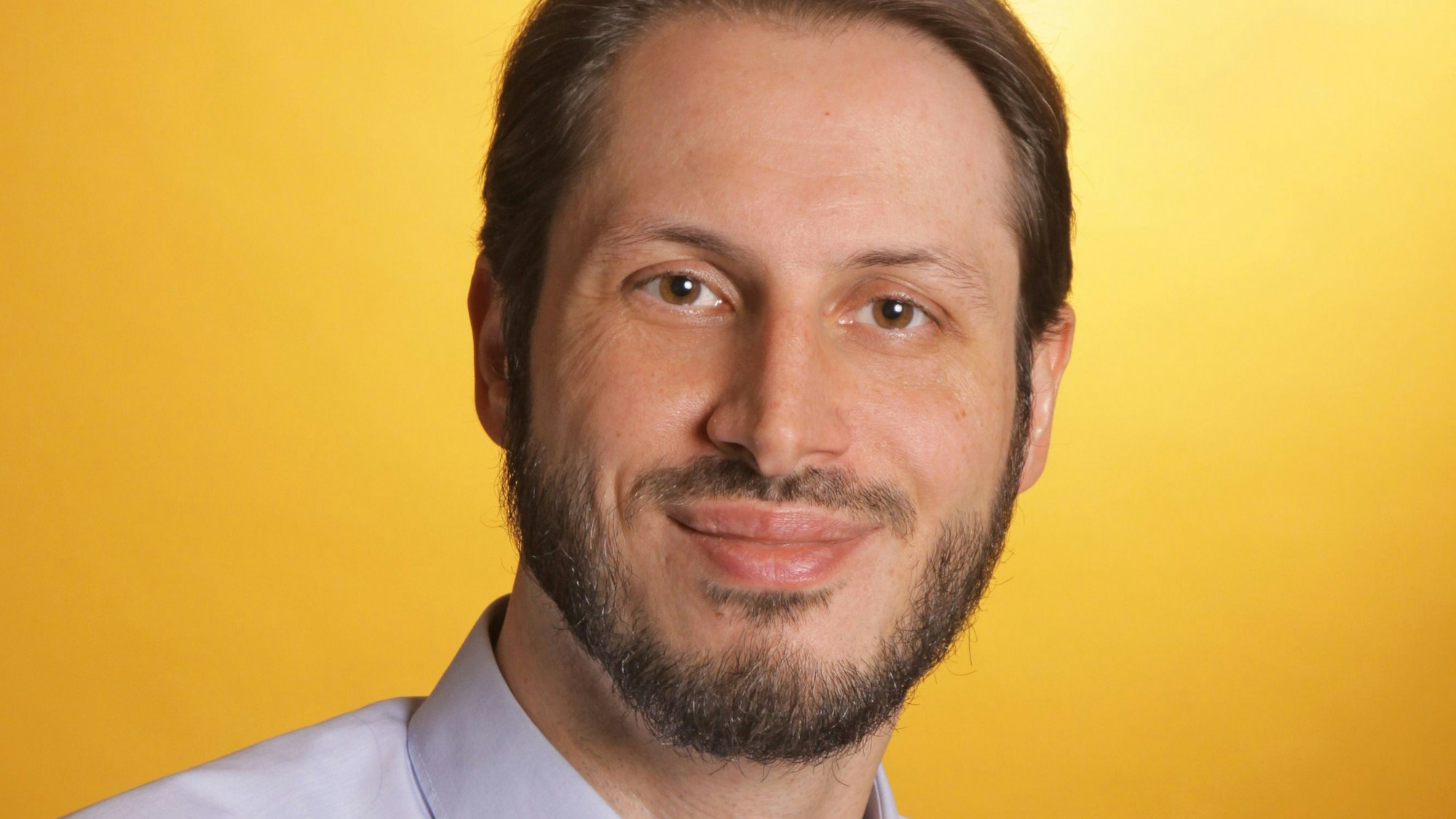 Auf dem Bild ist das Portrait eines Mannes zu sehen.